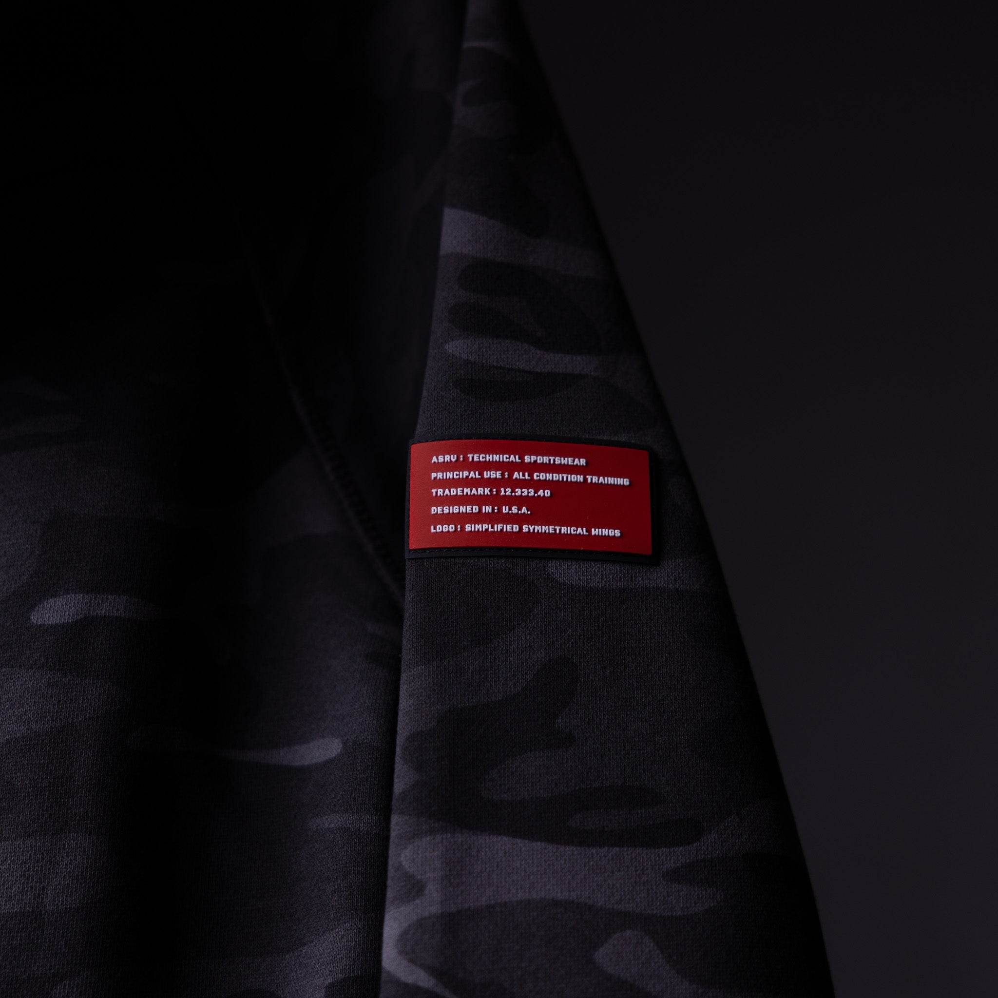 WN'19 RainPlus® Hoodie detail shot showing red care label on dark fabric