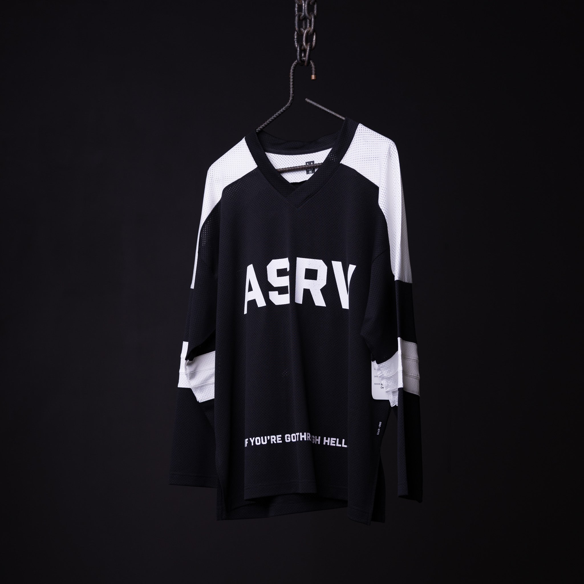SM'23 long-sleeve jersey in black and white on hanger against dark background