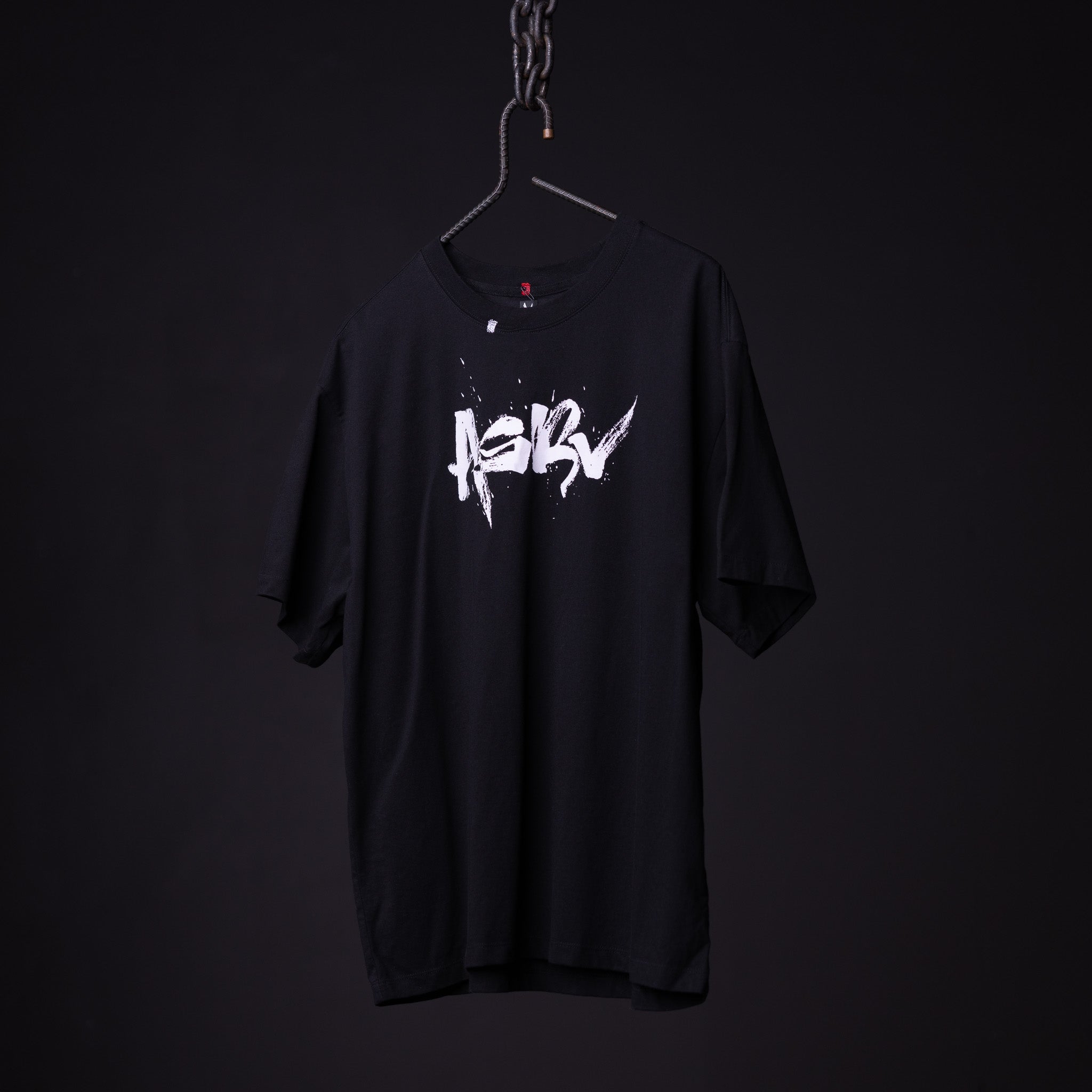 SP'23 Graphic Tee in black with white logo, displayed on hanger against dark background