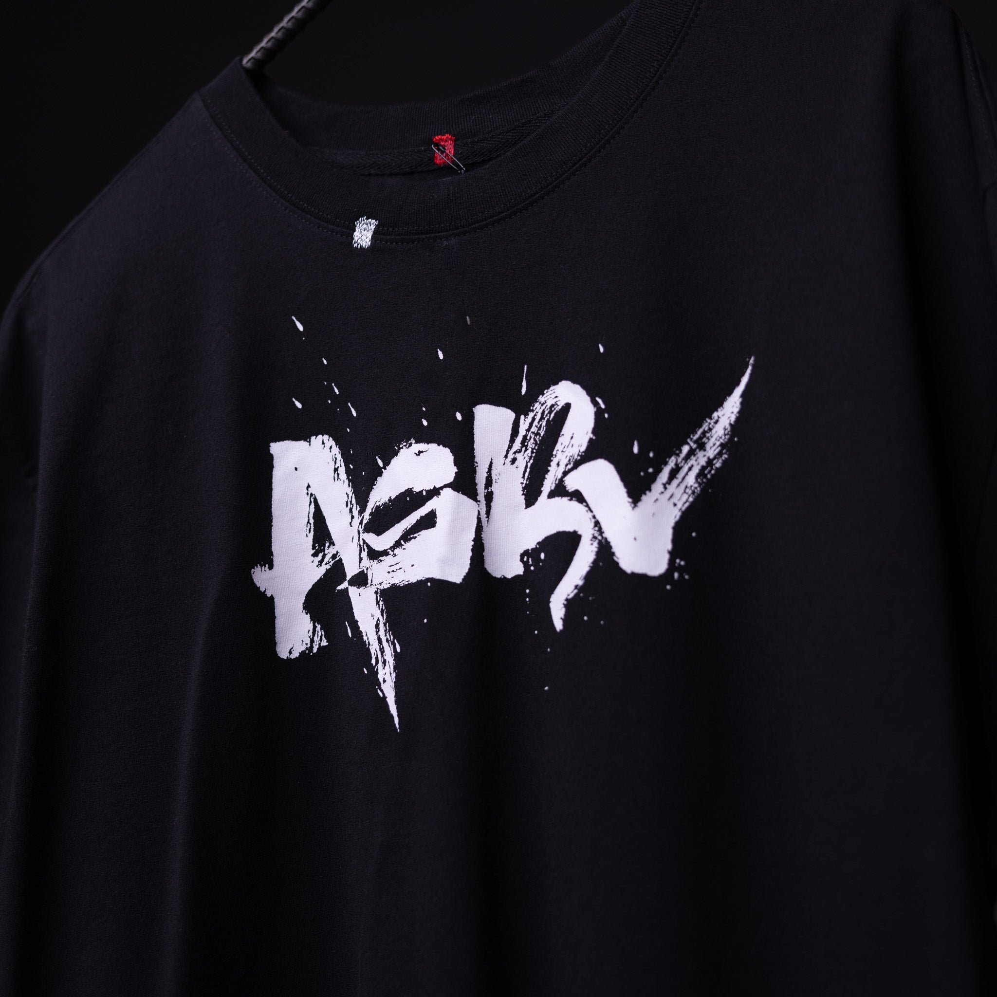 SP'23 Graphic Tee in black with white distressed logo design, worn on model