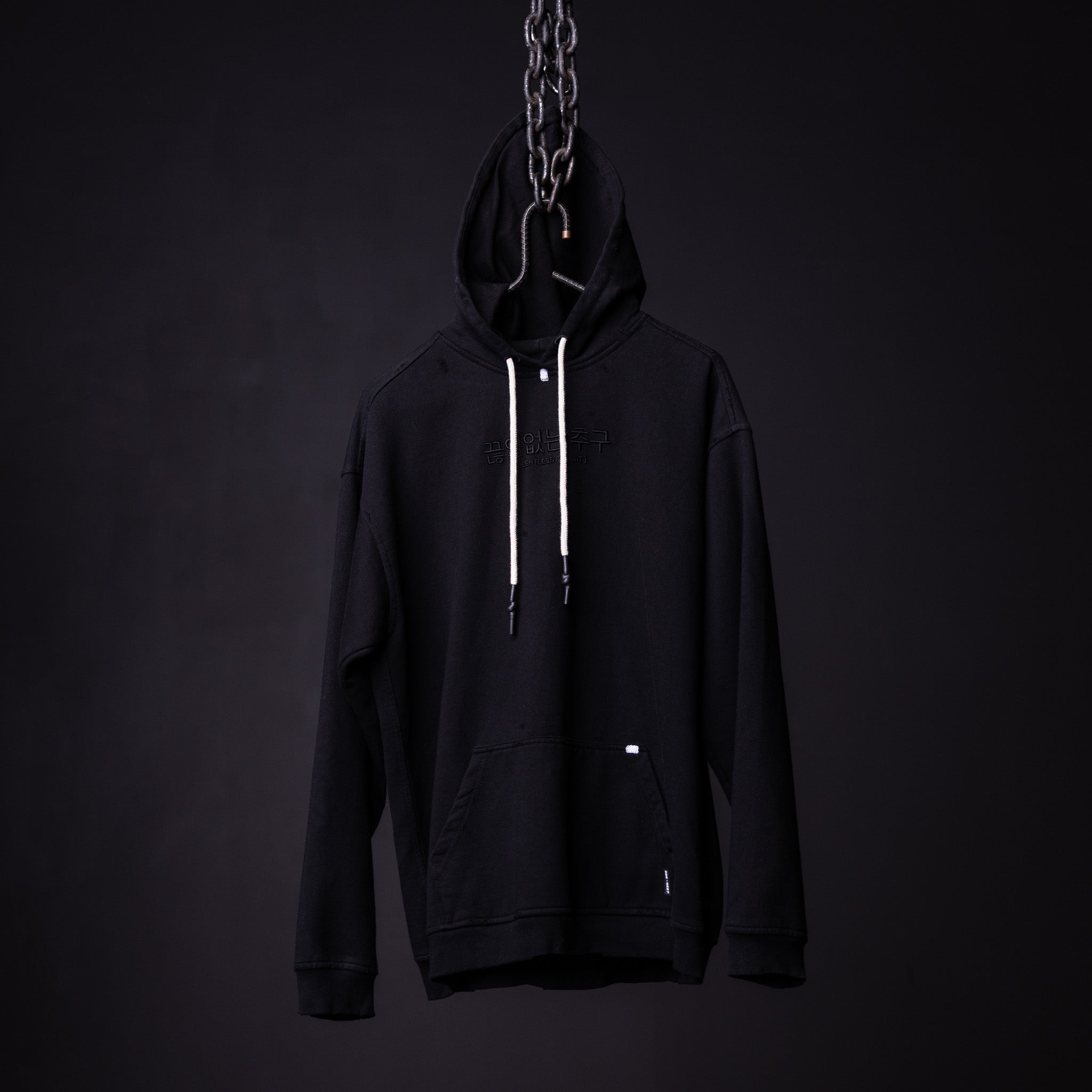 Black distressed hoodie on mannequin with chain detail, front view