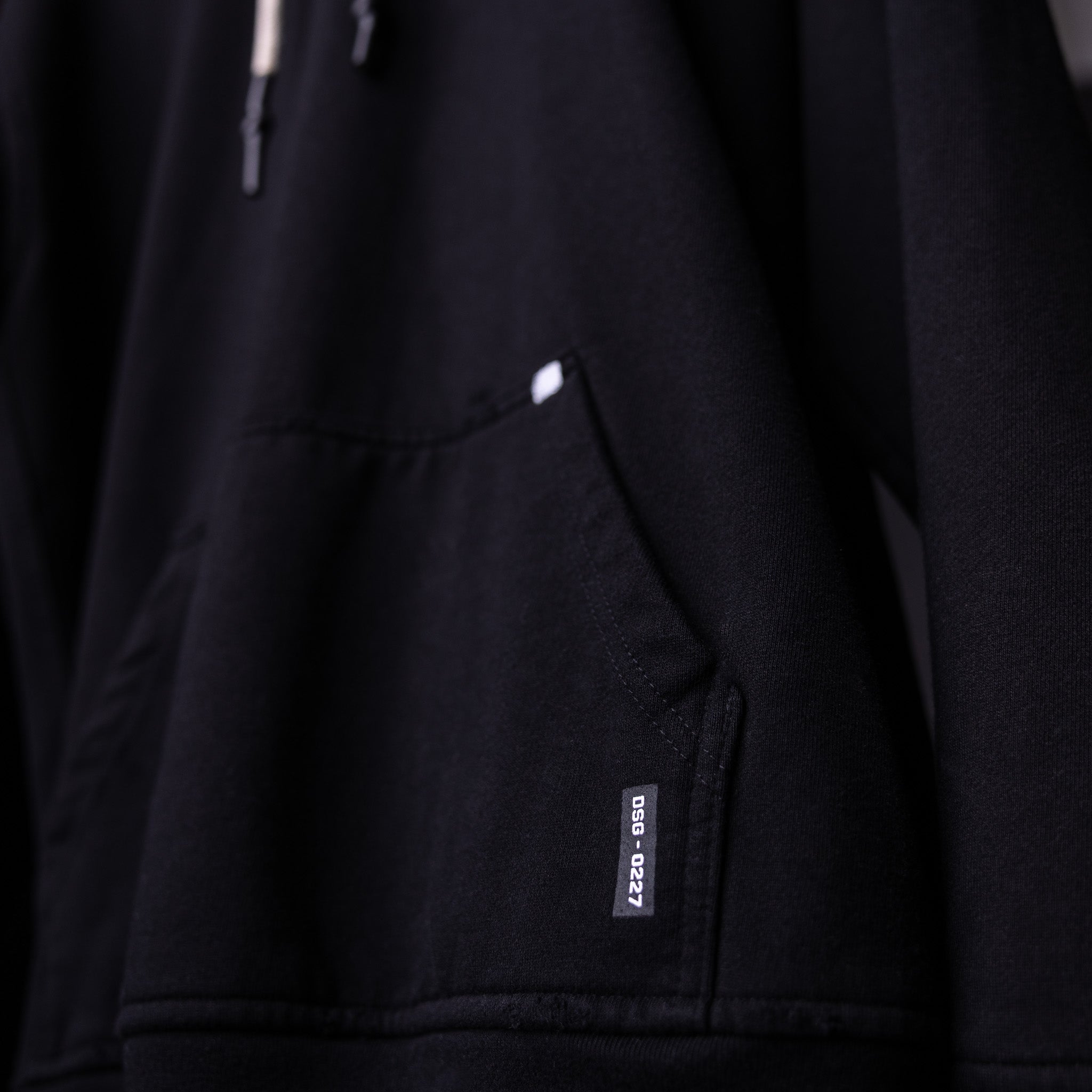 FA'20 Distressed Hoodie in black, detail shot of pocket and label