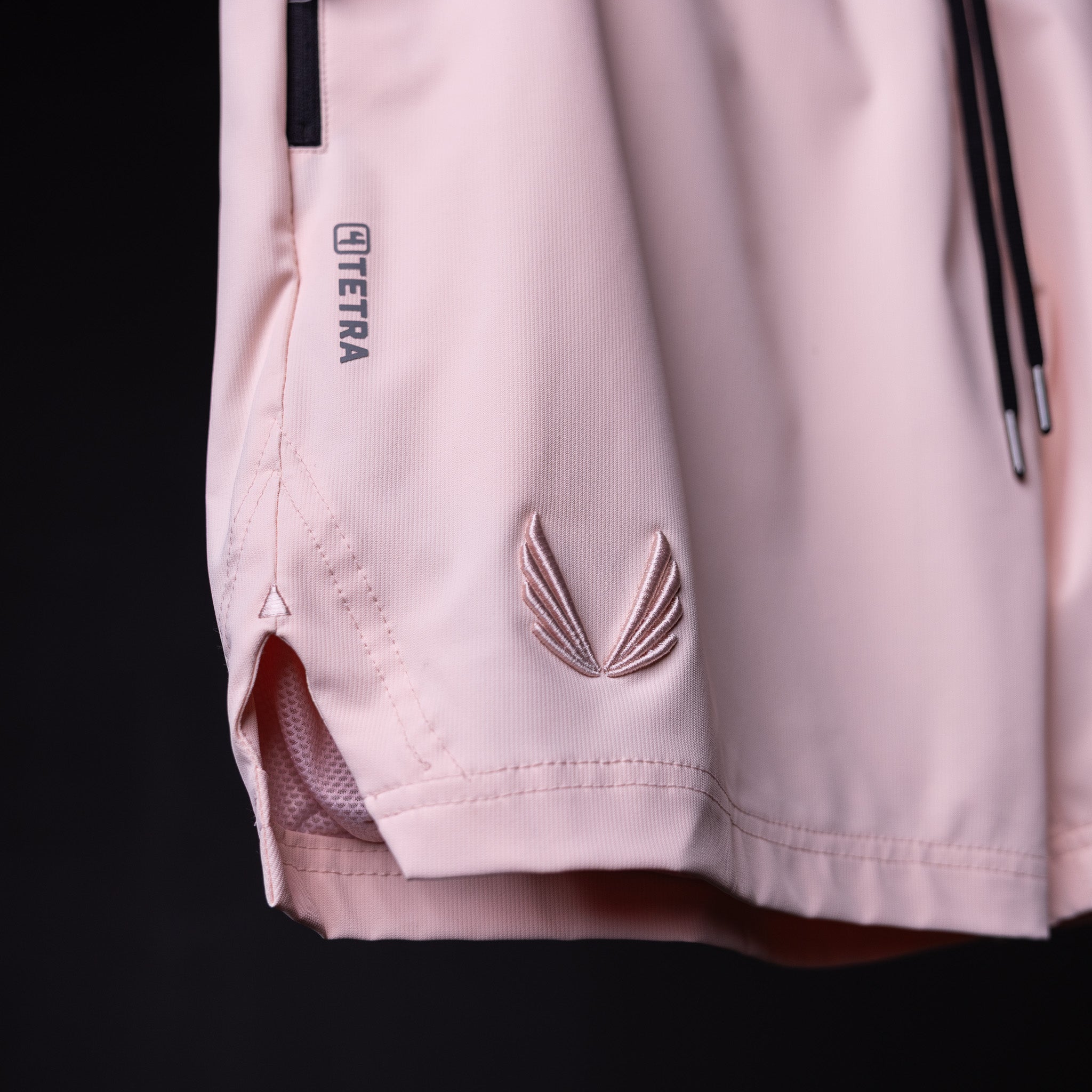 SP'21 Coastal Training Short detail shot showing mesh ventilation and embroidered logo on pink fabric