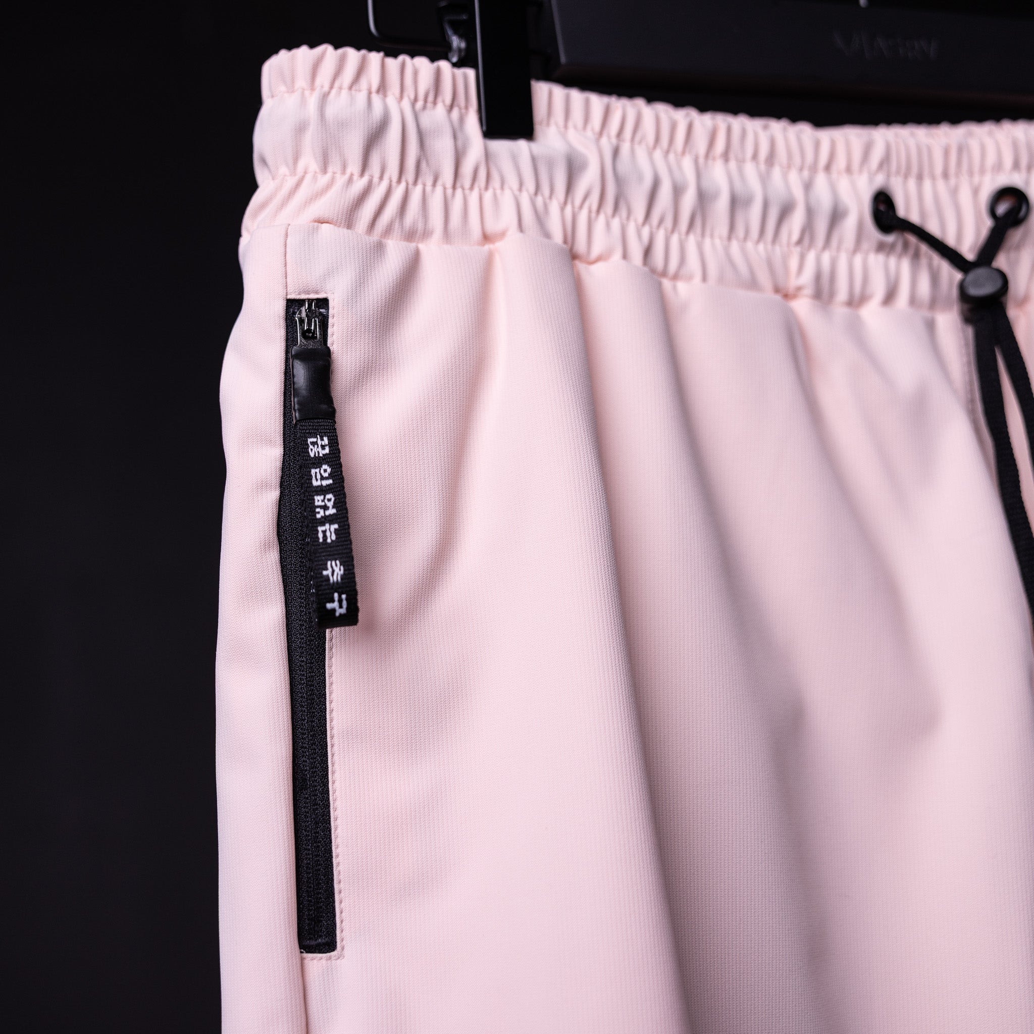 SP'21 Coastal Training Short in pink, detail shot of zipper pocket and drawstring