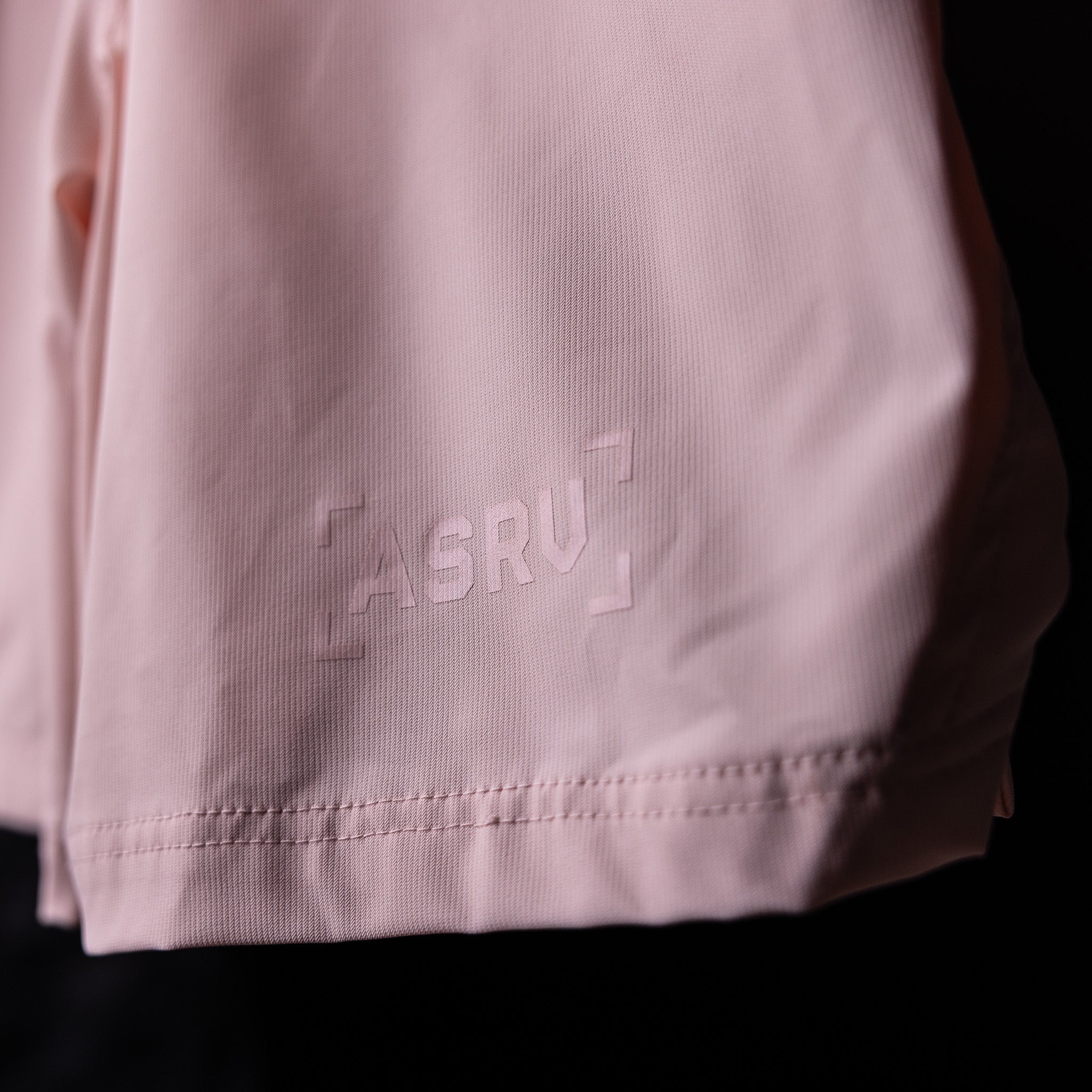 SP'21 Coastal Training Short in pink, detail shot of side seam and branding