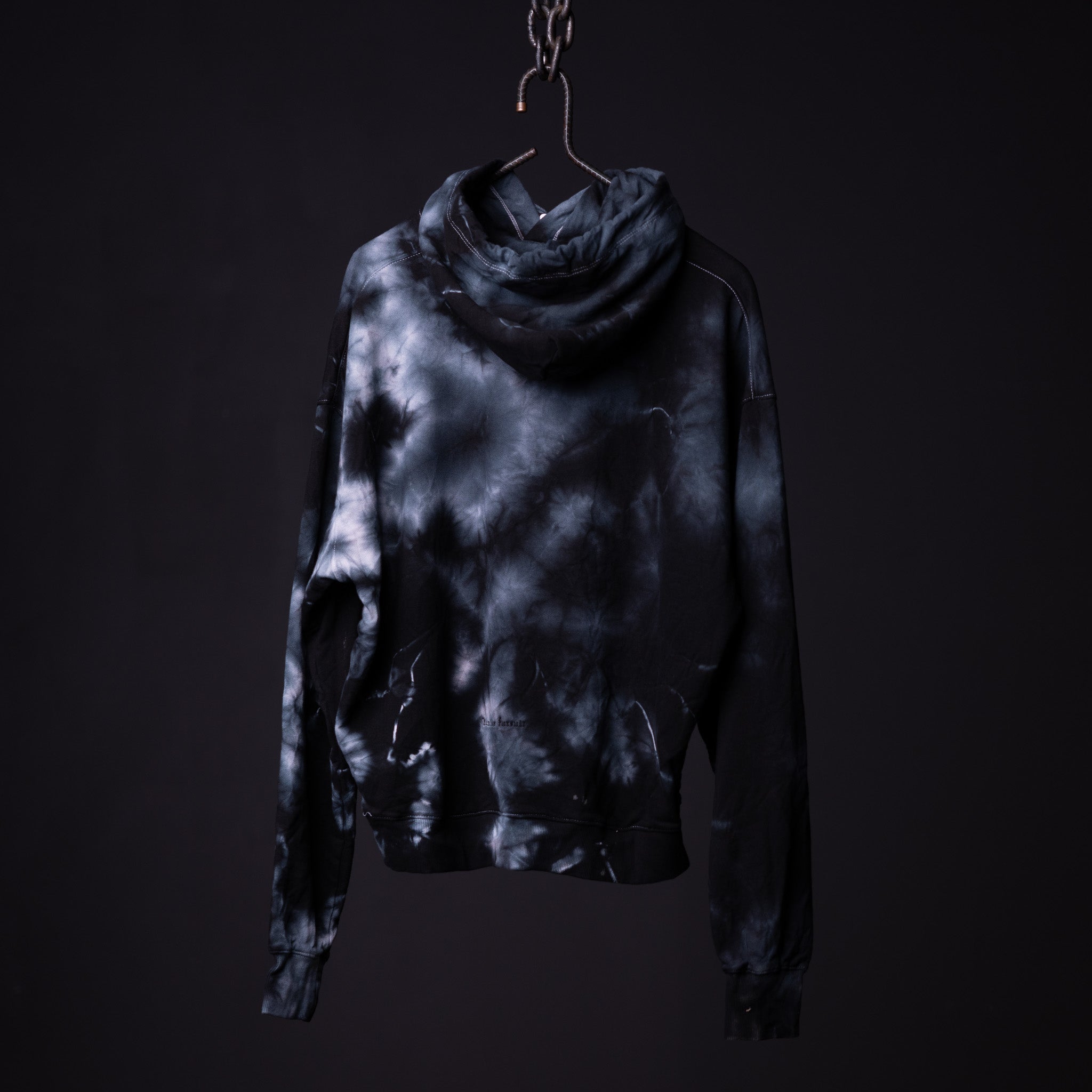 SM'22 Tie Dye Hoodie in black and white tie dye, displayed on hanger against dark background