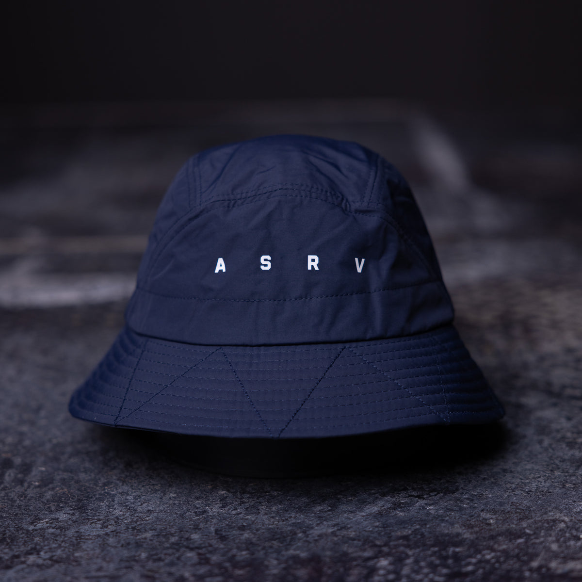 WN'22 Cinch Bucket Hat in navy blue, front view on dark surface