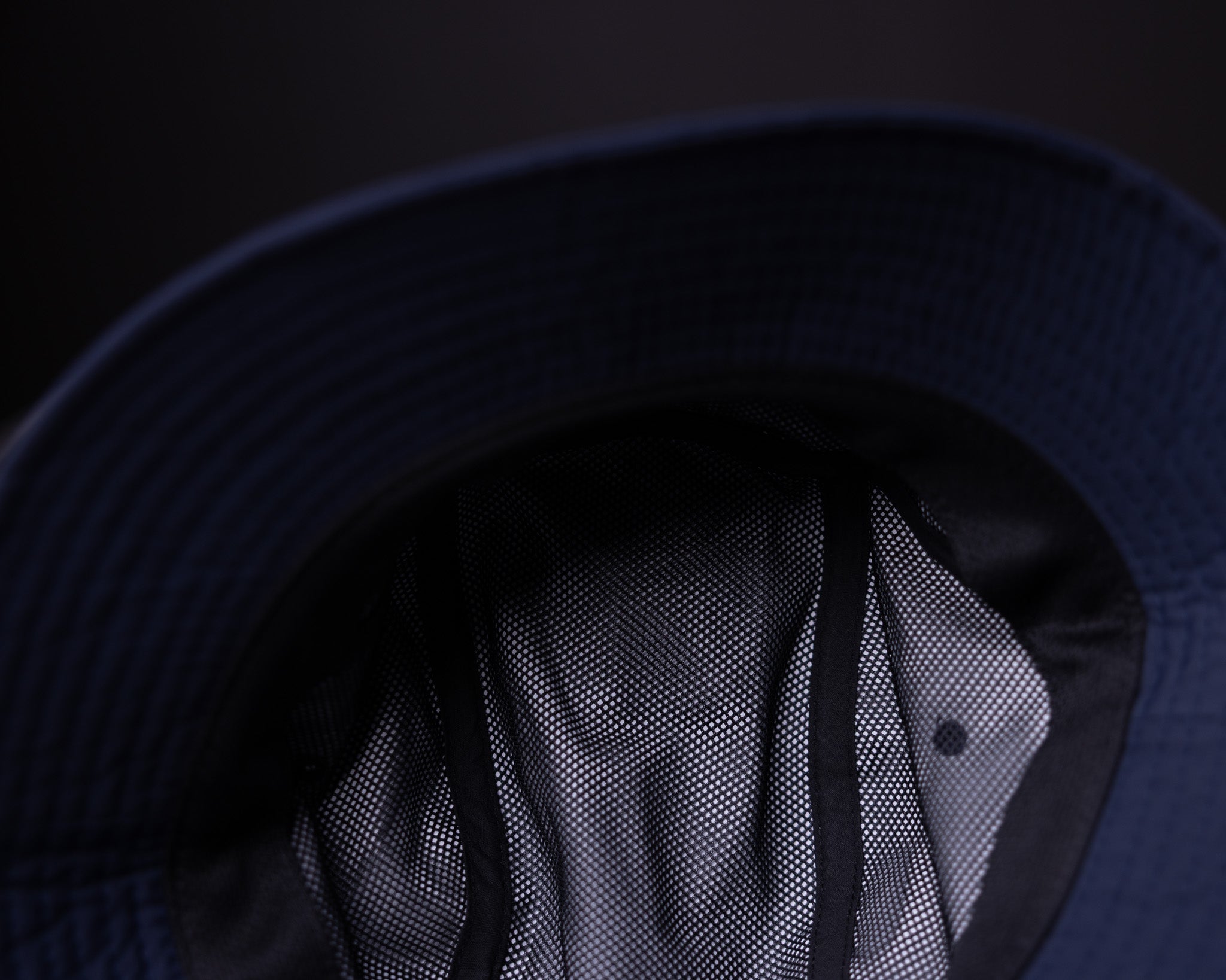 WN'22 Cinch Bucket Hat in navy, worn with mesh detail visible from front angle