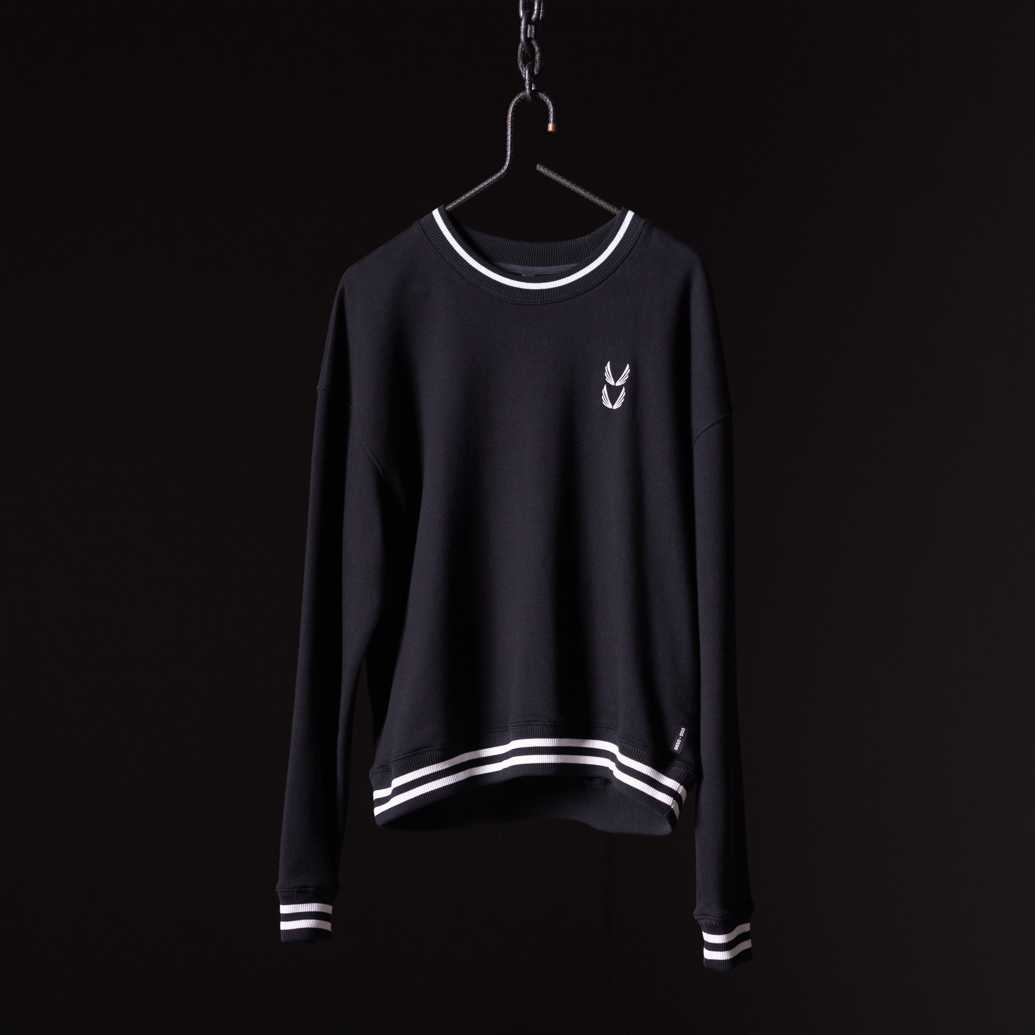 Navy crew neck sweatshirt with white stripe trim on hanger against black background