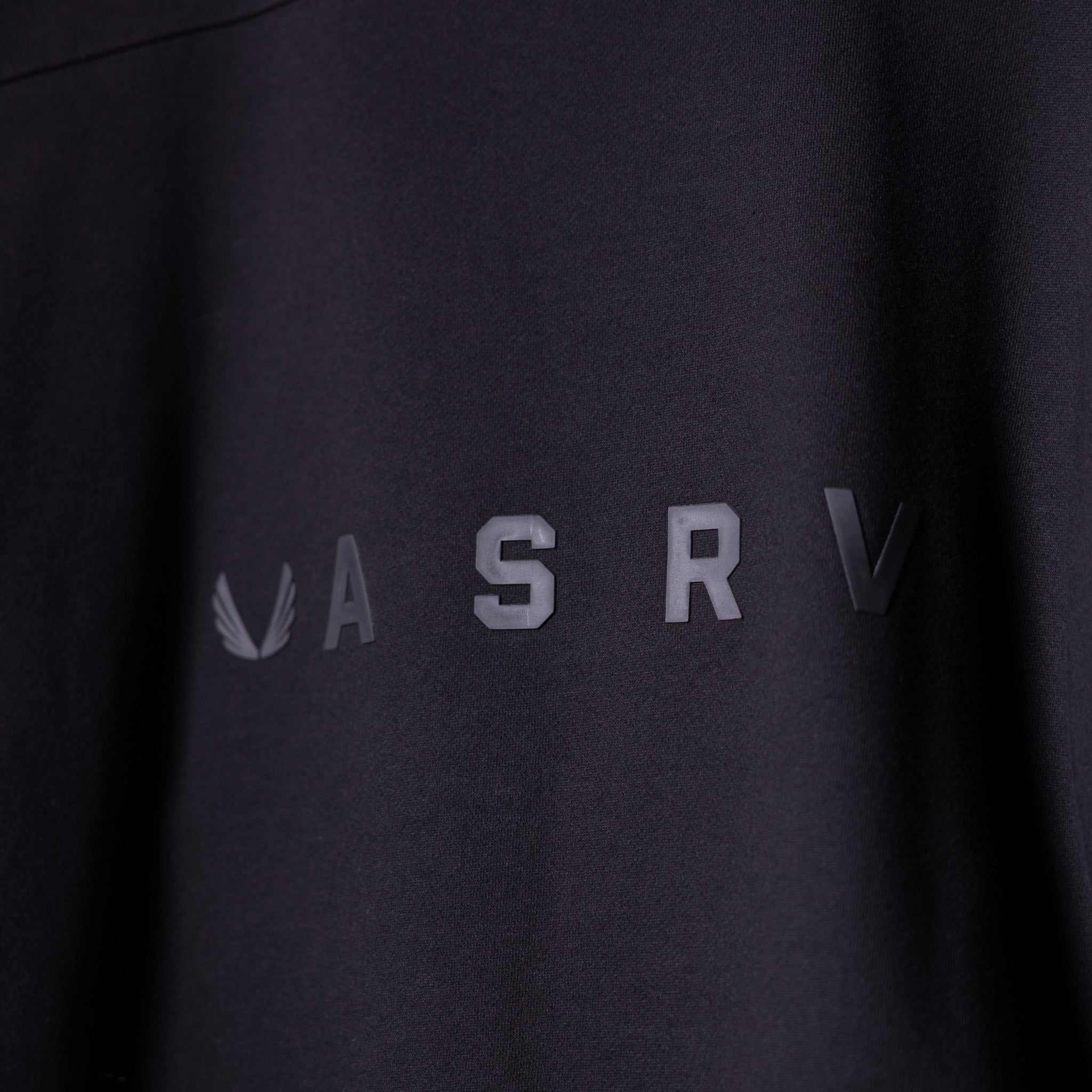 ASRV Zip Pocket Quarter Zip in black, worn on model showing chest logo detail