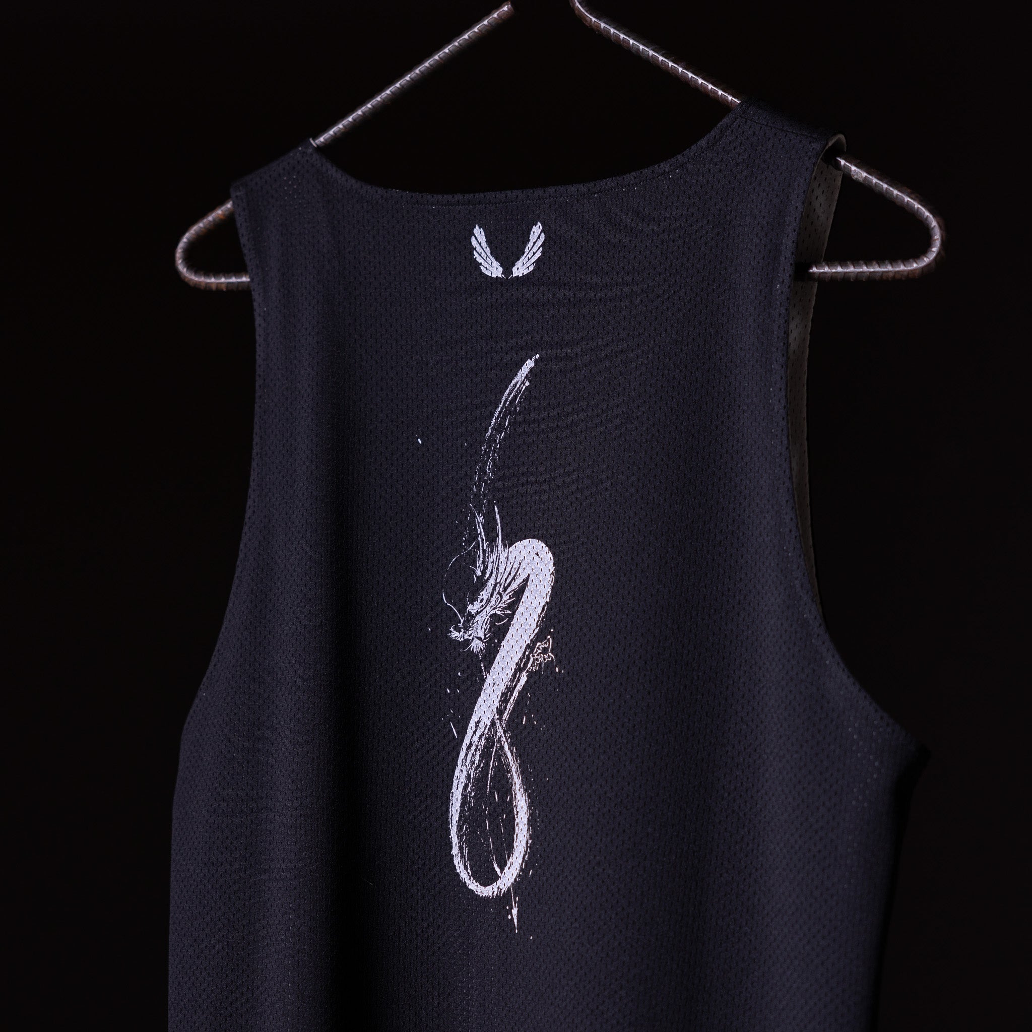 SM'23 Mesh Reversible Pinnie in black on hanger, back view with graphic design
