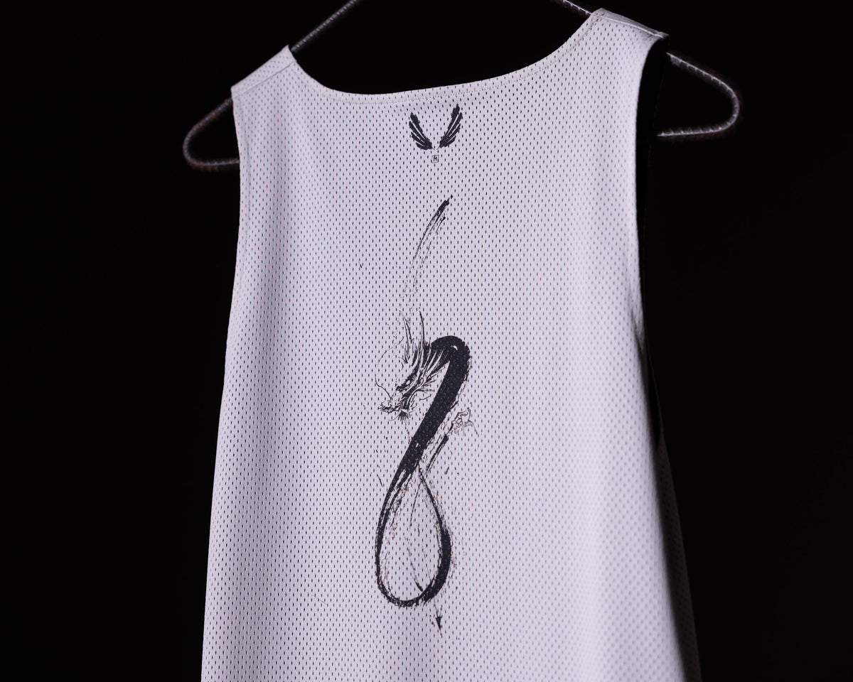SM'23 Mesh Reversible Pinnie in white, displayed on hanger with graphic design detail