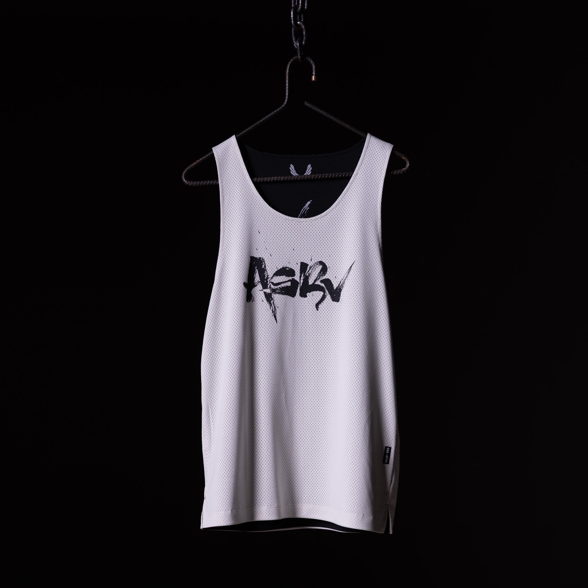 SM'23 Mesh Reversible Pinnie in white, displayed on hanger against black background