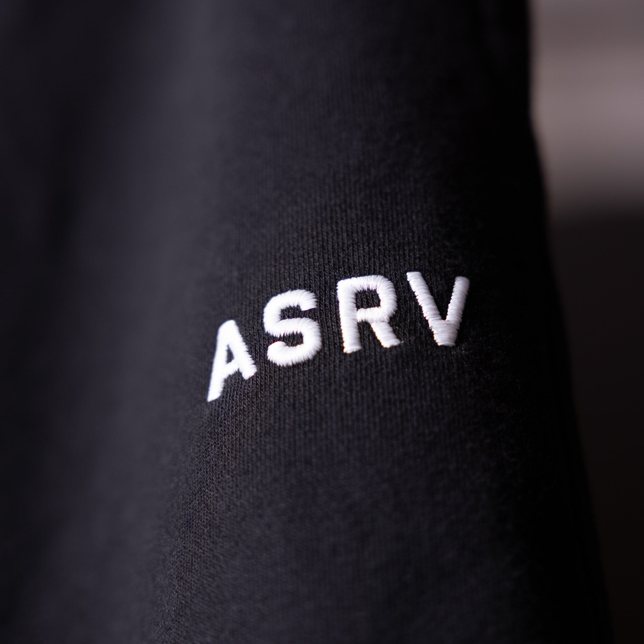 FA'23 Straight Leg Jogger in black, closeup of ASRV logo on fabric