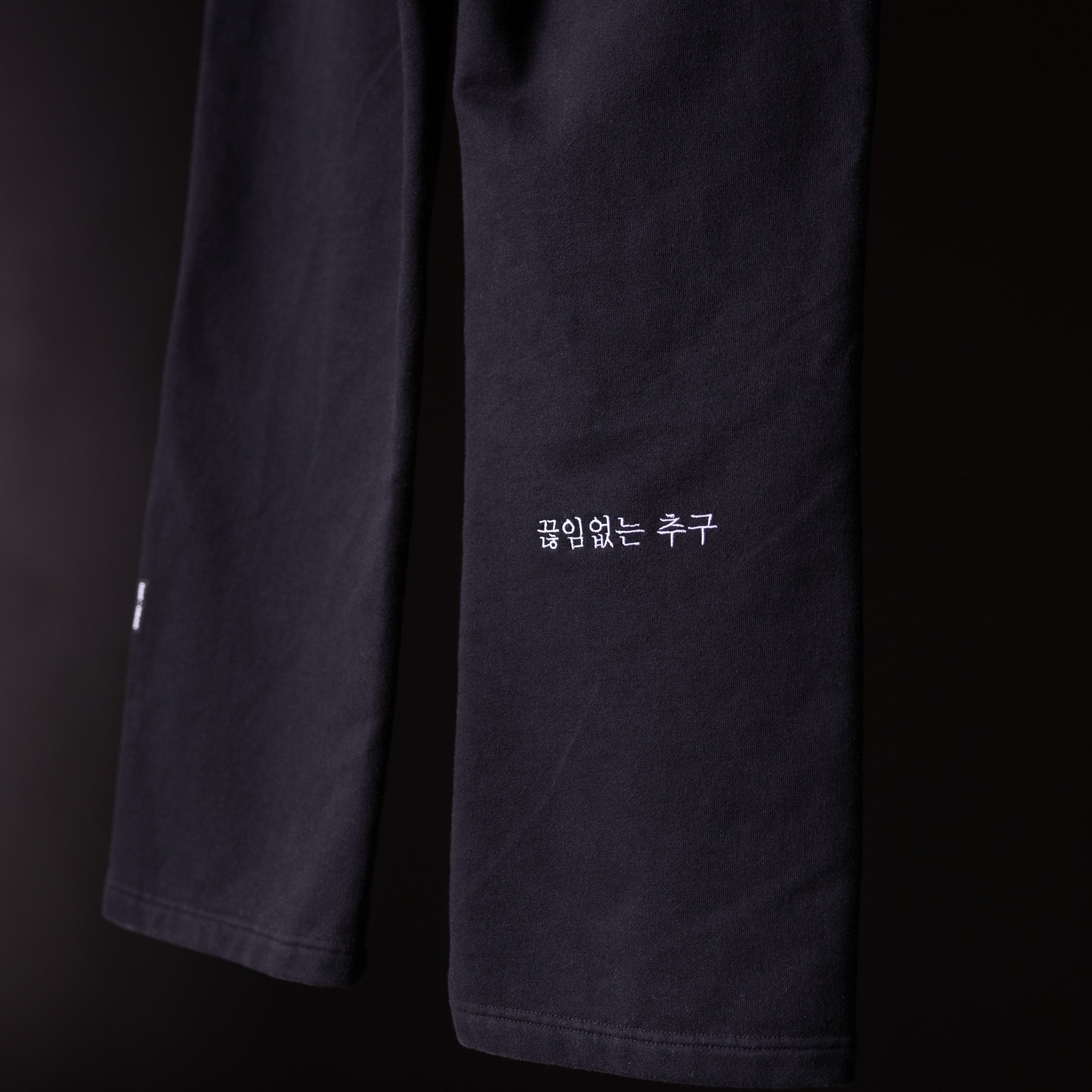 FA'23 Straight Leg Jogger in black, close-up detail of pant legs with Korean text