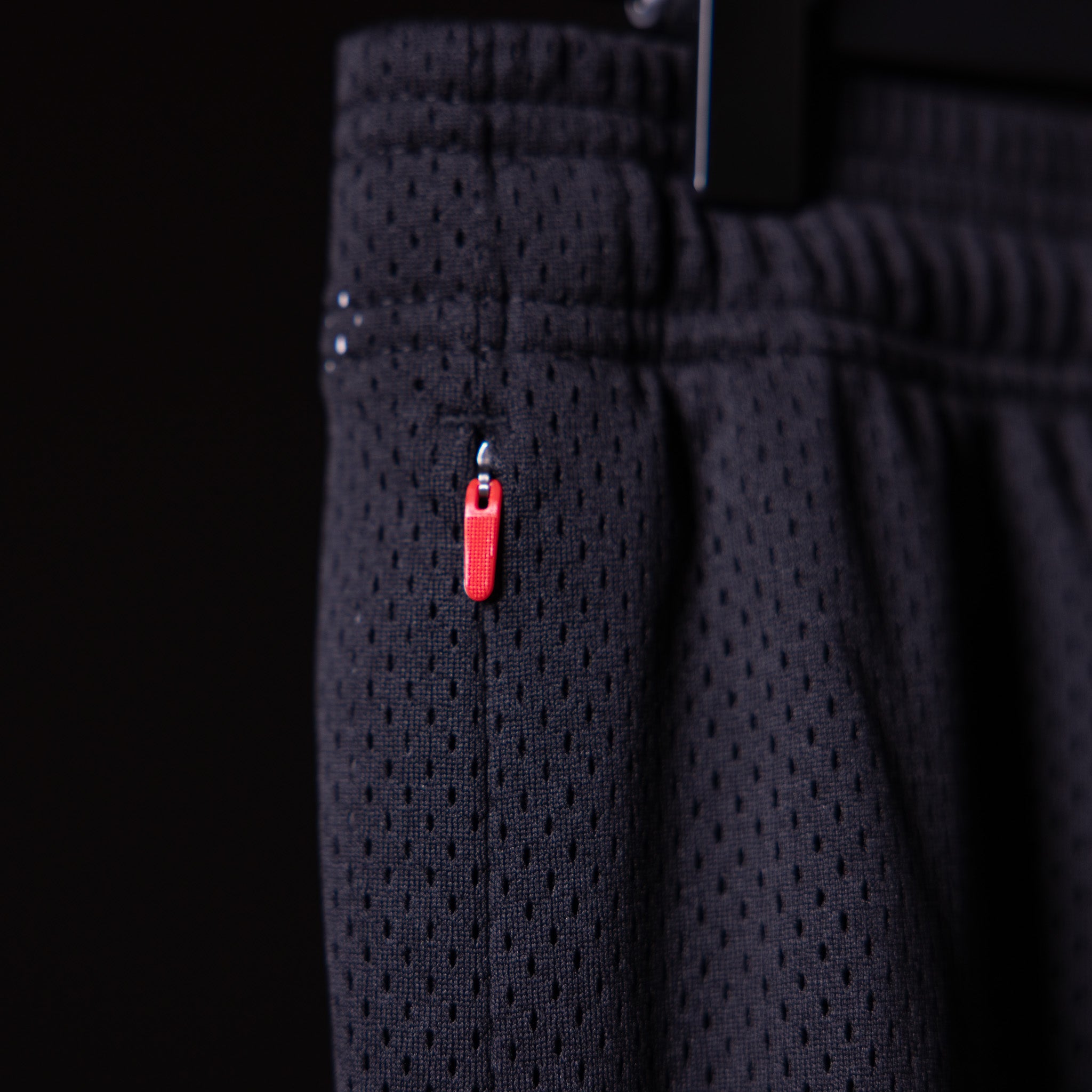 Training Division Mesh Shorts in black, worn with red zip detail visible on thigh