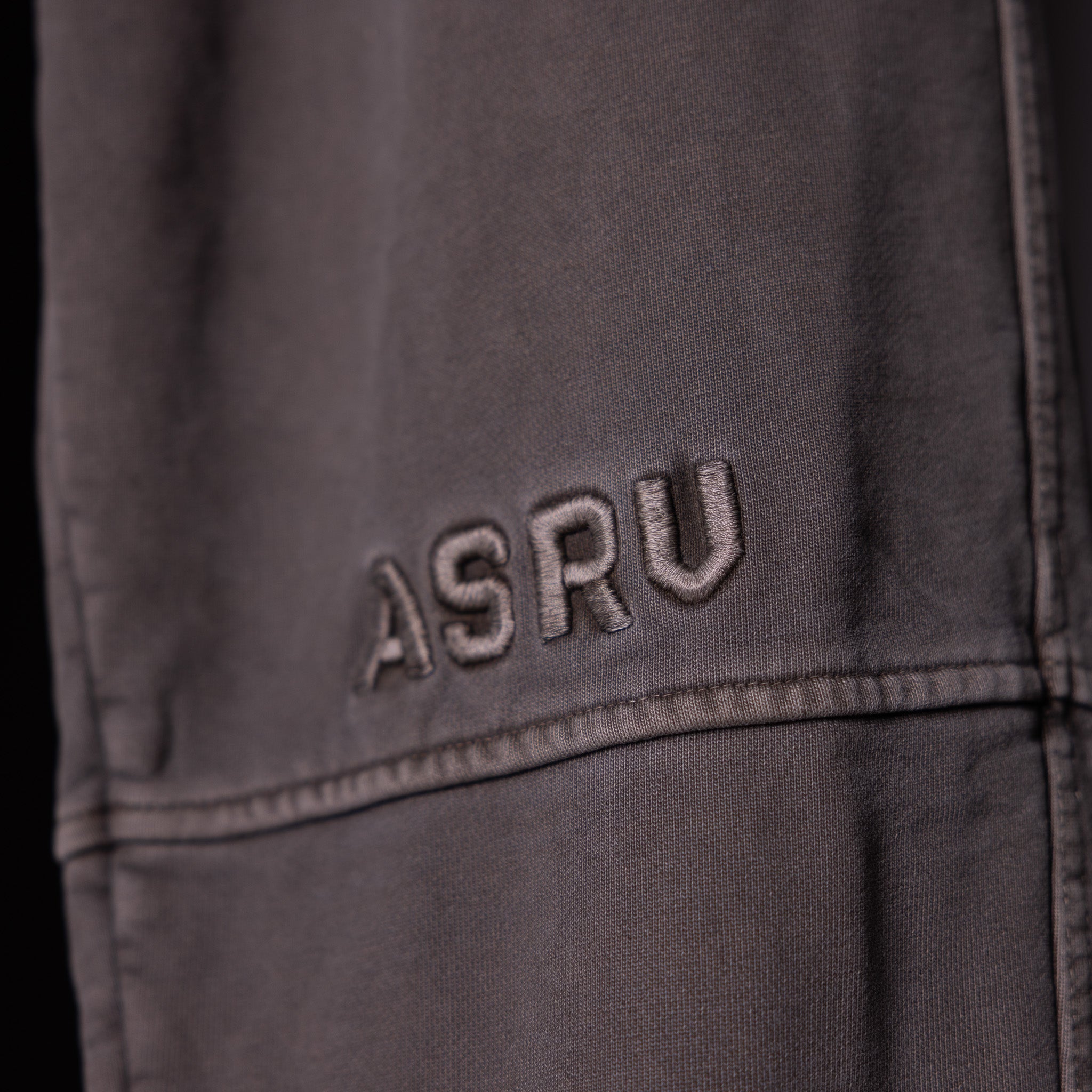 WN'20 Terry Relaxed Jogger in charcoal, detail shot of embroidered ASRV logo on thigh