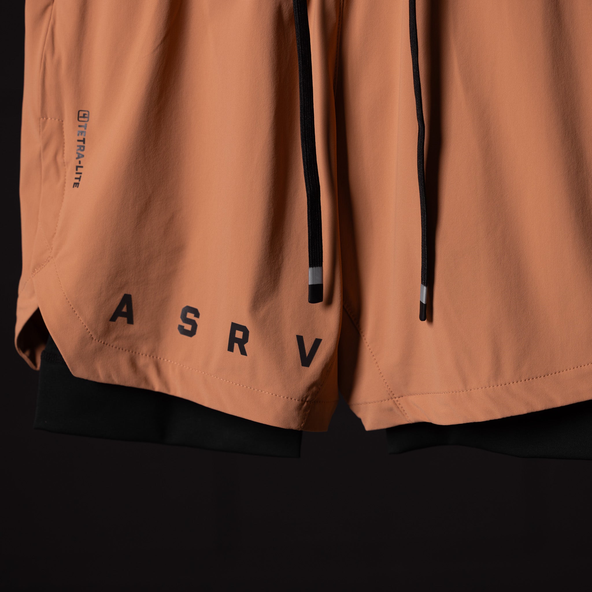 FA'22 7" Liner Short in tan, detail shot showing hem branding and drawstring