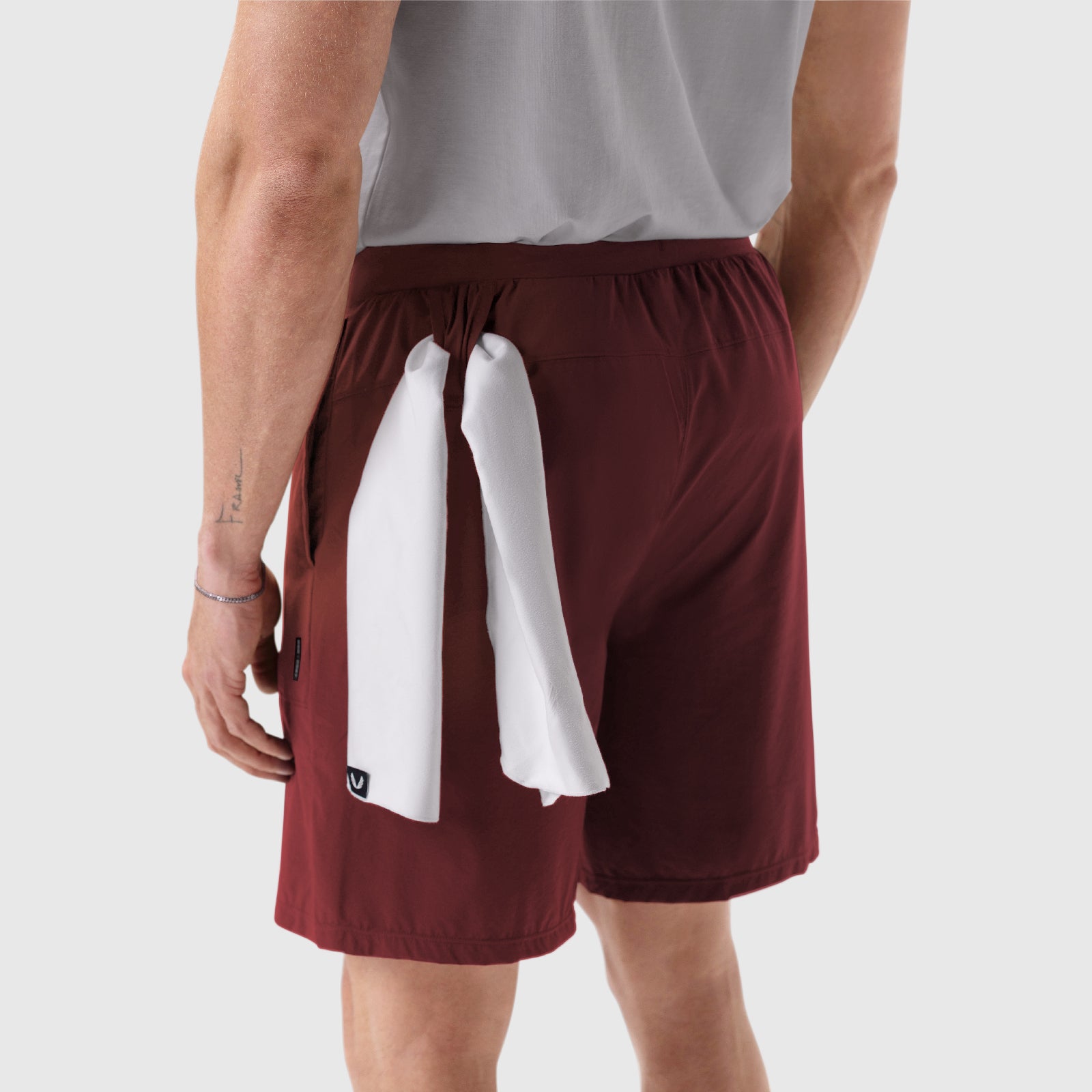 Aerotex Training Short in crimson with white towel, worn by model, side view