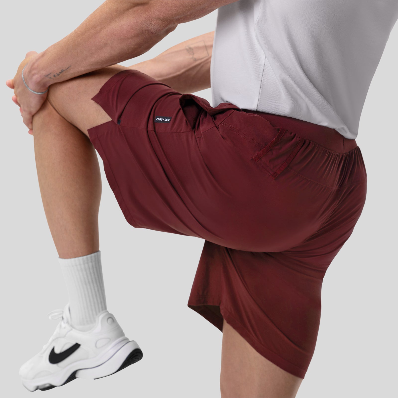 Aerotex™ 8" Training Short in Crimson, worn by model stretching leg