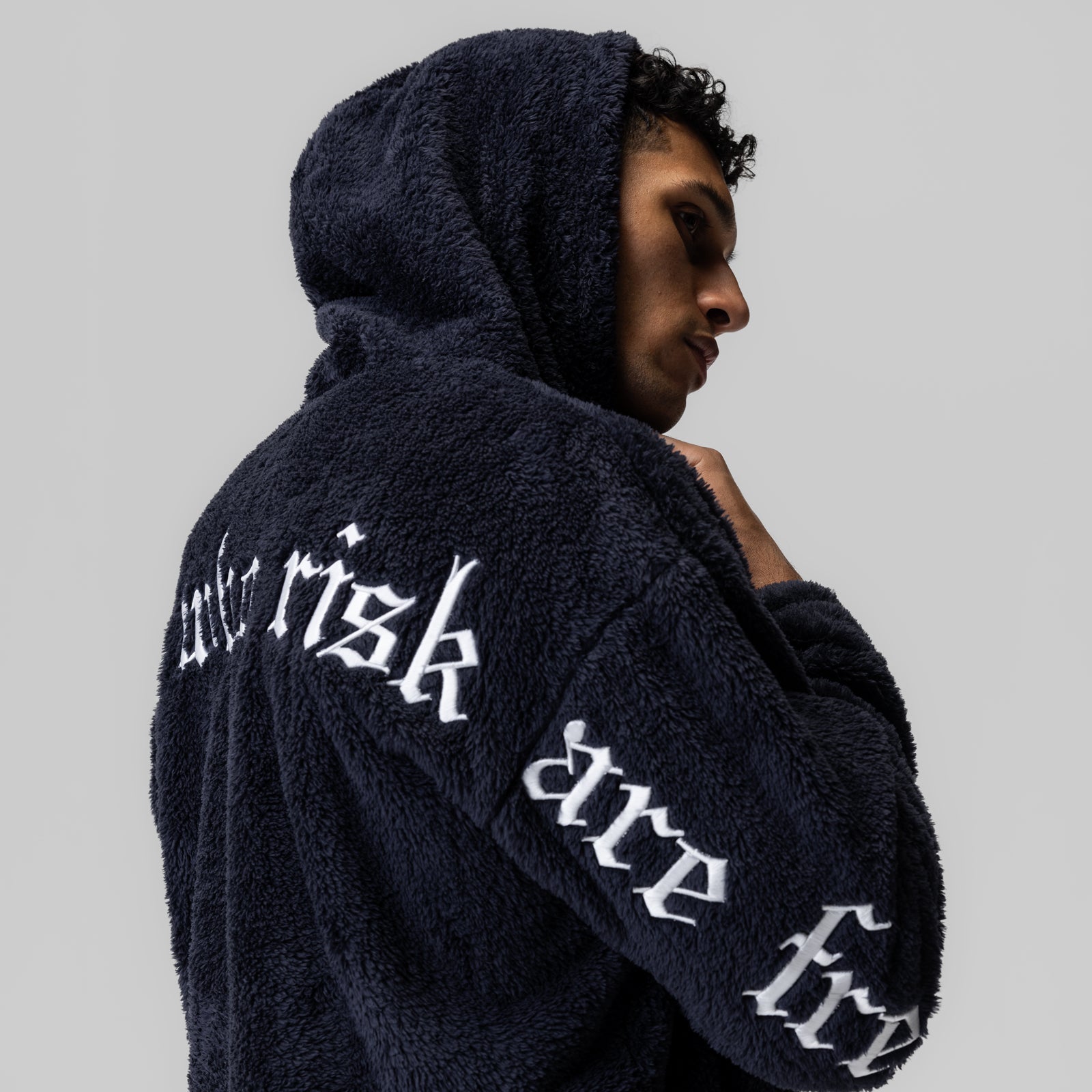 Navy Sherpa Recovery Hoodie with white text on back, worn by model in profile