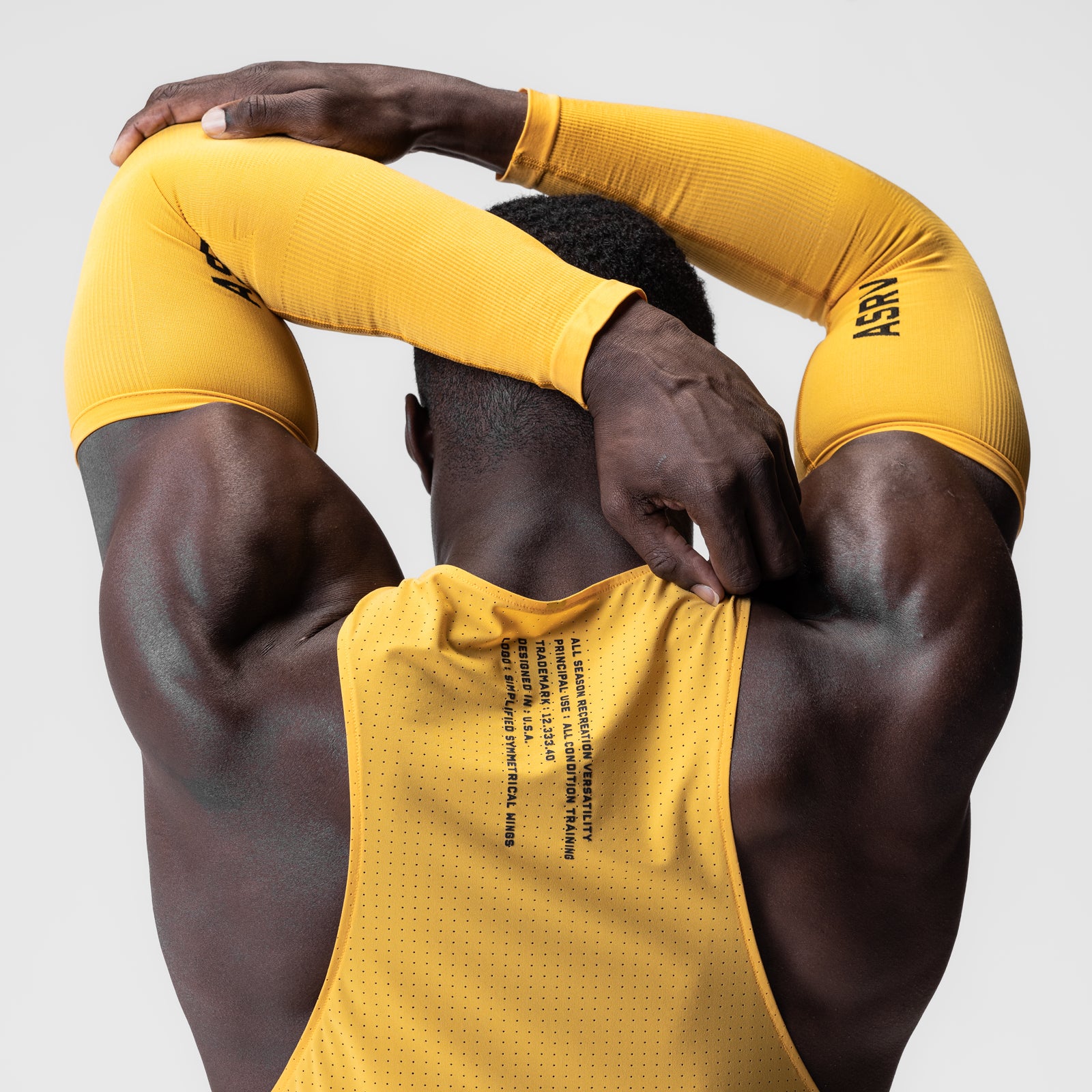 Body-Mapped Arm Sleeve in amber yellow worn by model with arms raised behind head