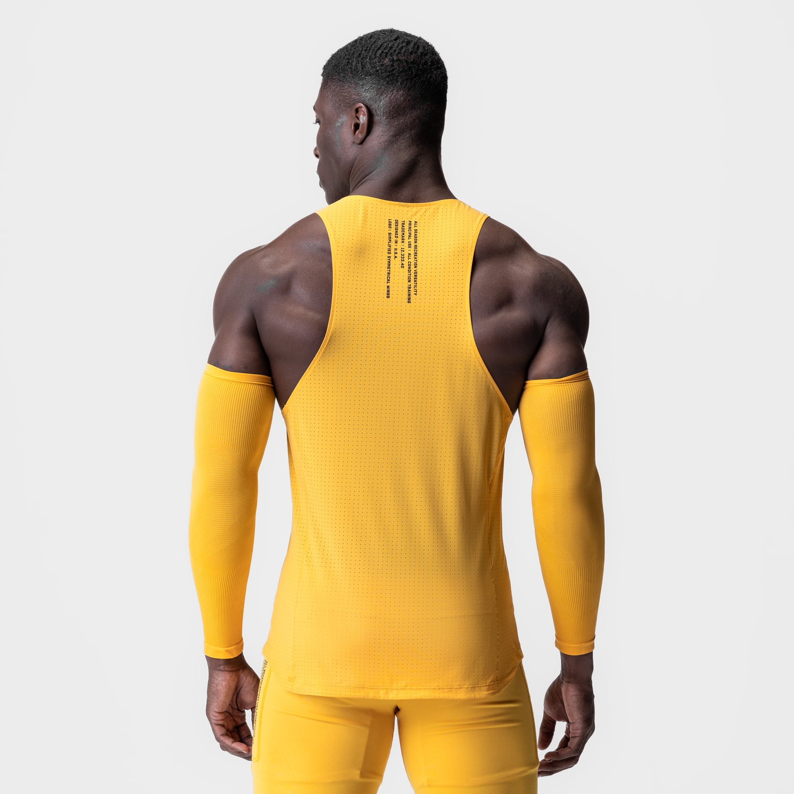 Laser-Vent™ Singlet Tank in amber yellow worn by male model, back view with arm sleeves
