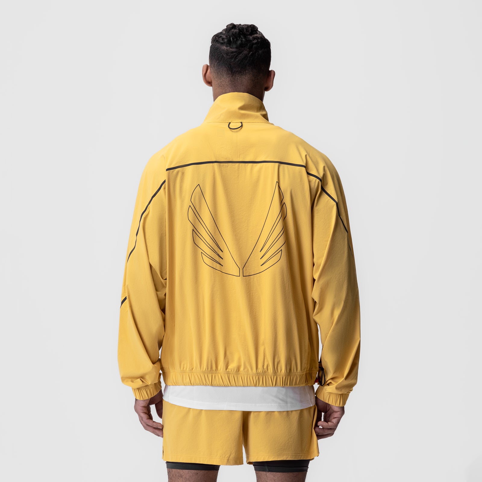 Aerotex Track Jacket in amber yellow with black piping, back view on model