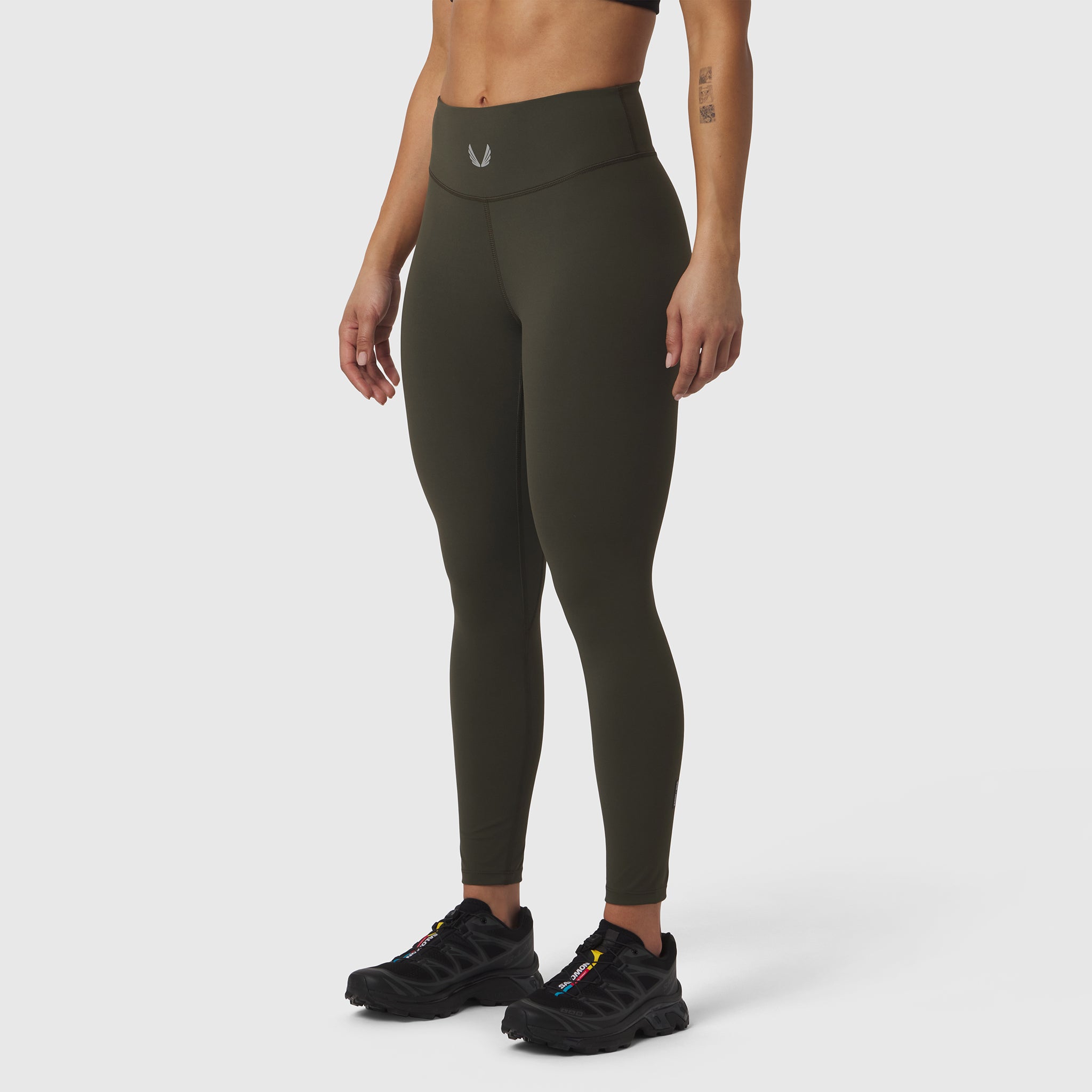 W002 LYCRA® ADAPTIV legging in olive, modeled from waist down with black sneakers