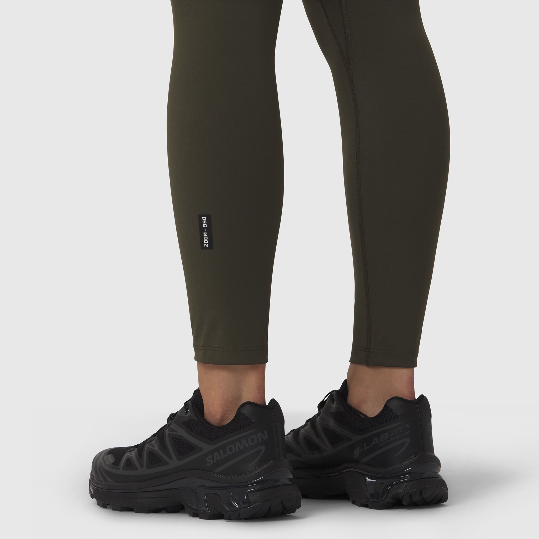 W002 LYCRA® ADAPTIV legging in olive worn with black sneakers, lower body view