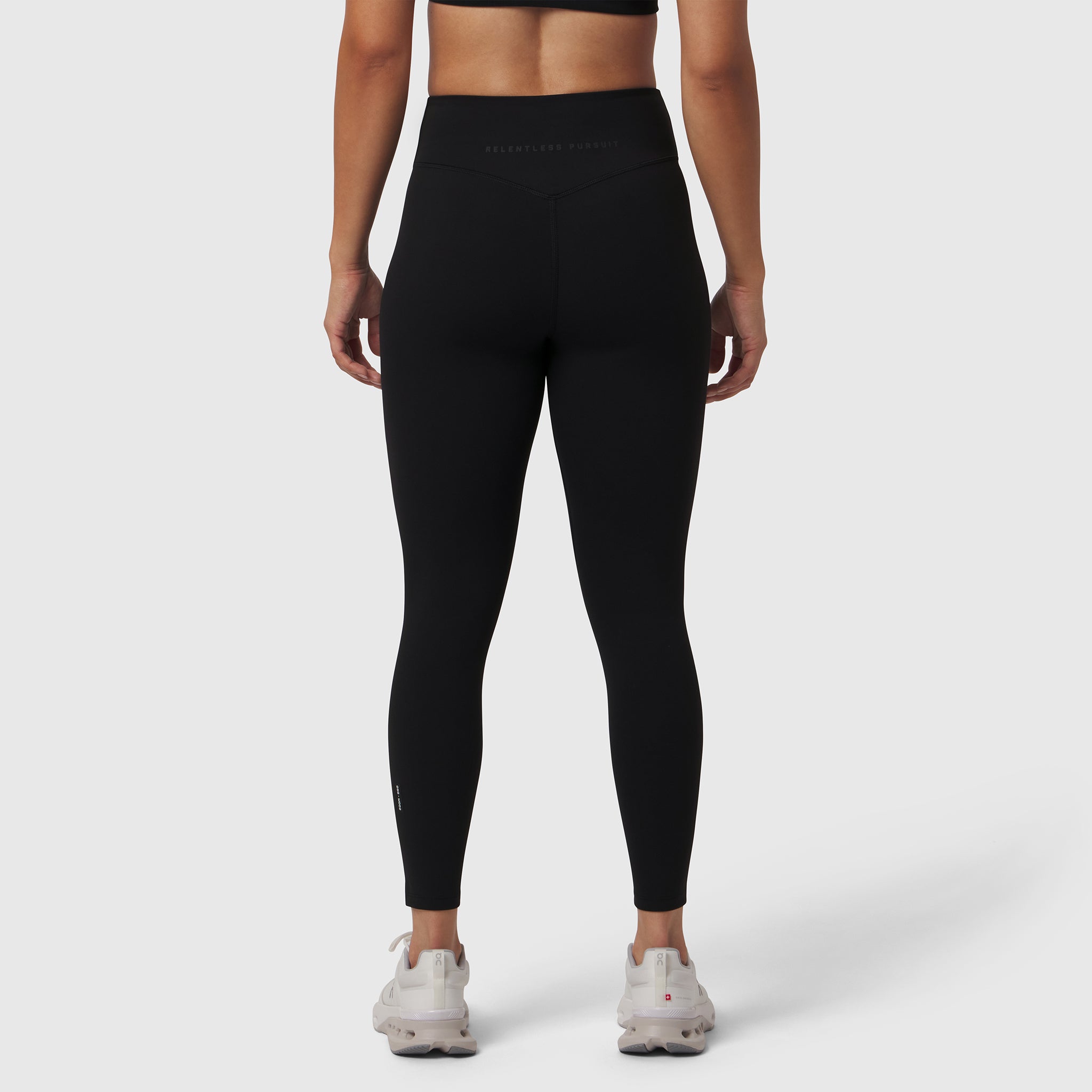 Black LYCRA® ADAPTIV legging on model, back view, paired with white sneakers