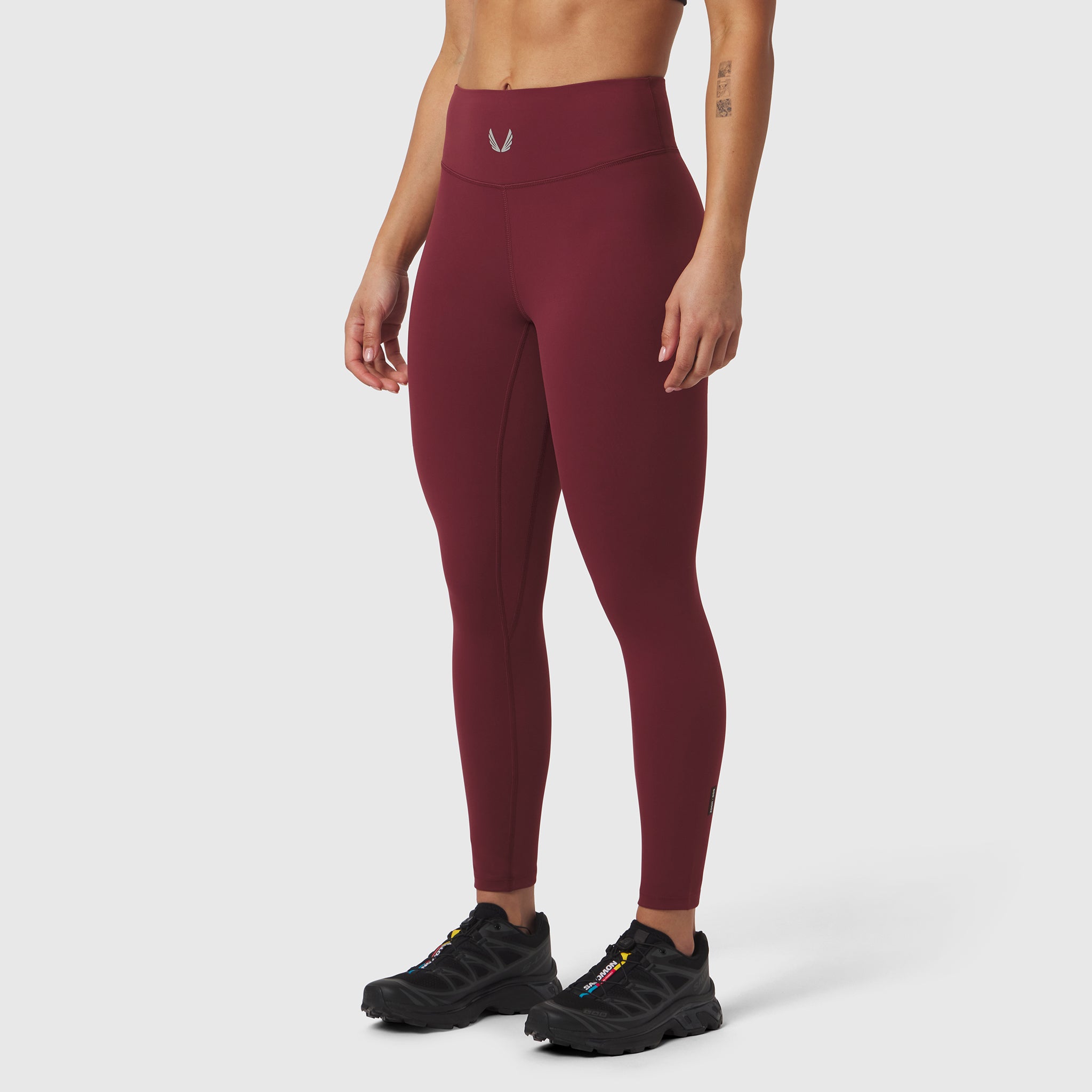 W002 LYCRA® ADAPTIV Legging in crimson, worn by model with black sneakers, side view