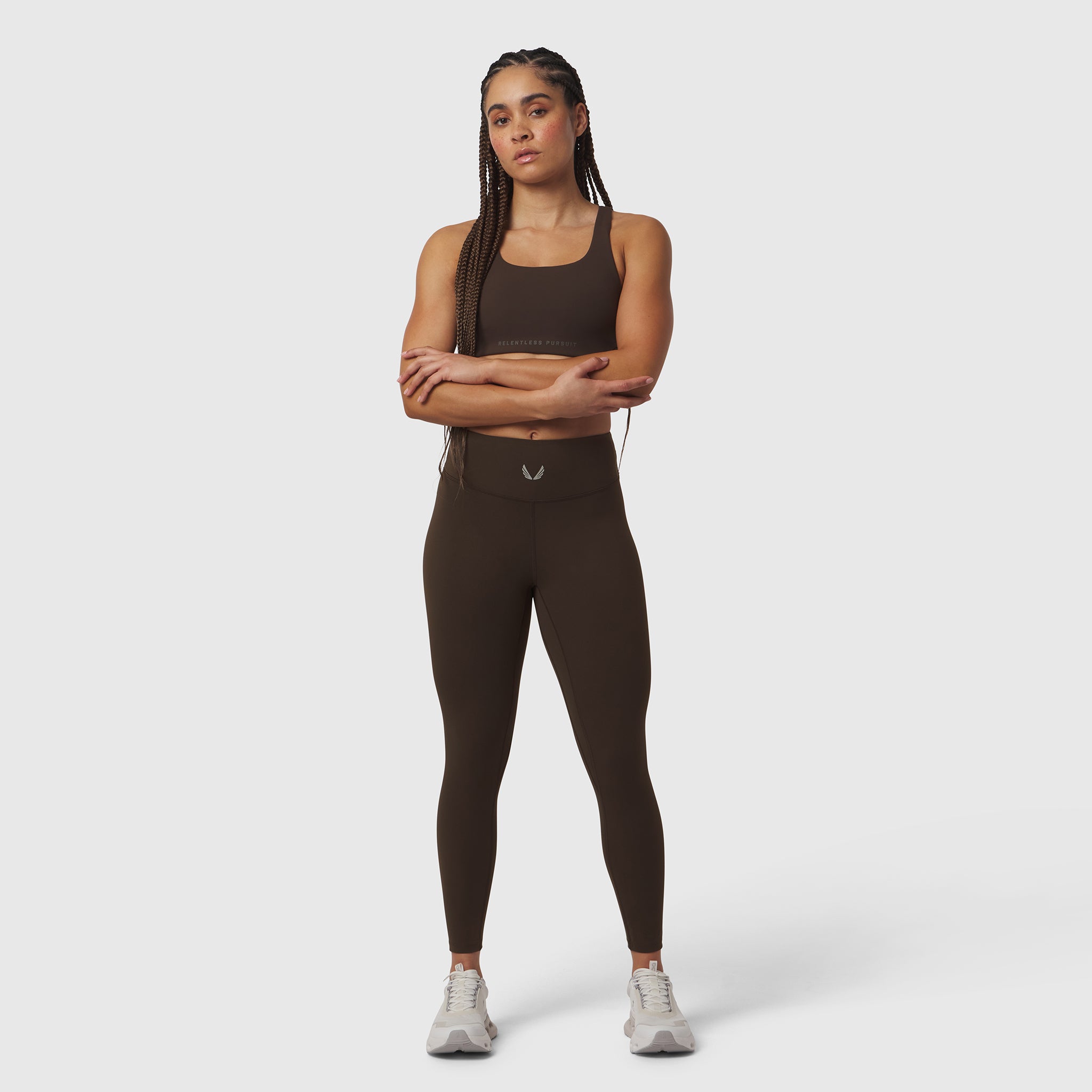 W002 LYCRA® ADAPTIV Legging in dark earth, worn by model standing with arms crossed
