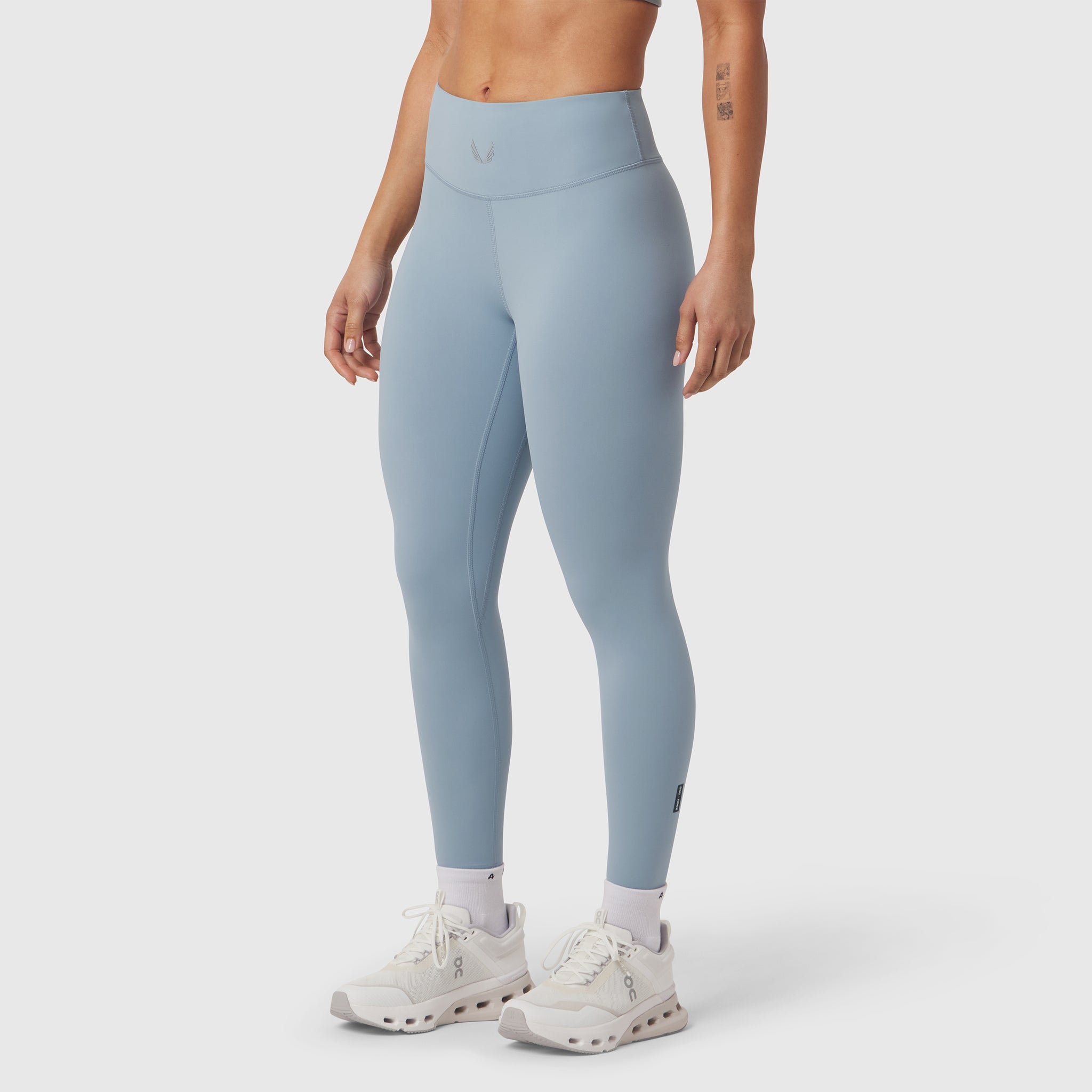 W002 LYCRA® ADAPTIV legging in light sky, worn with white sneakers, side view
