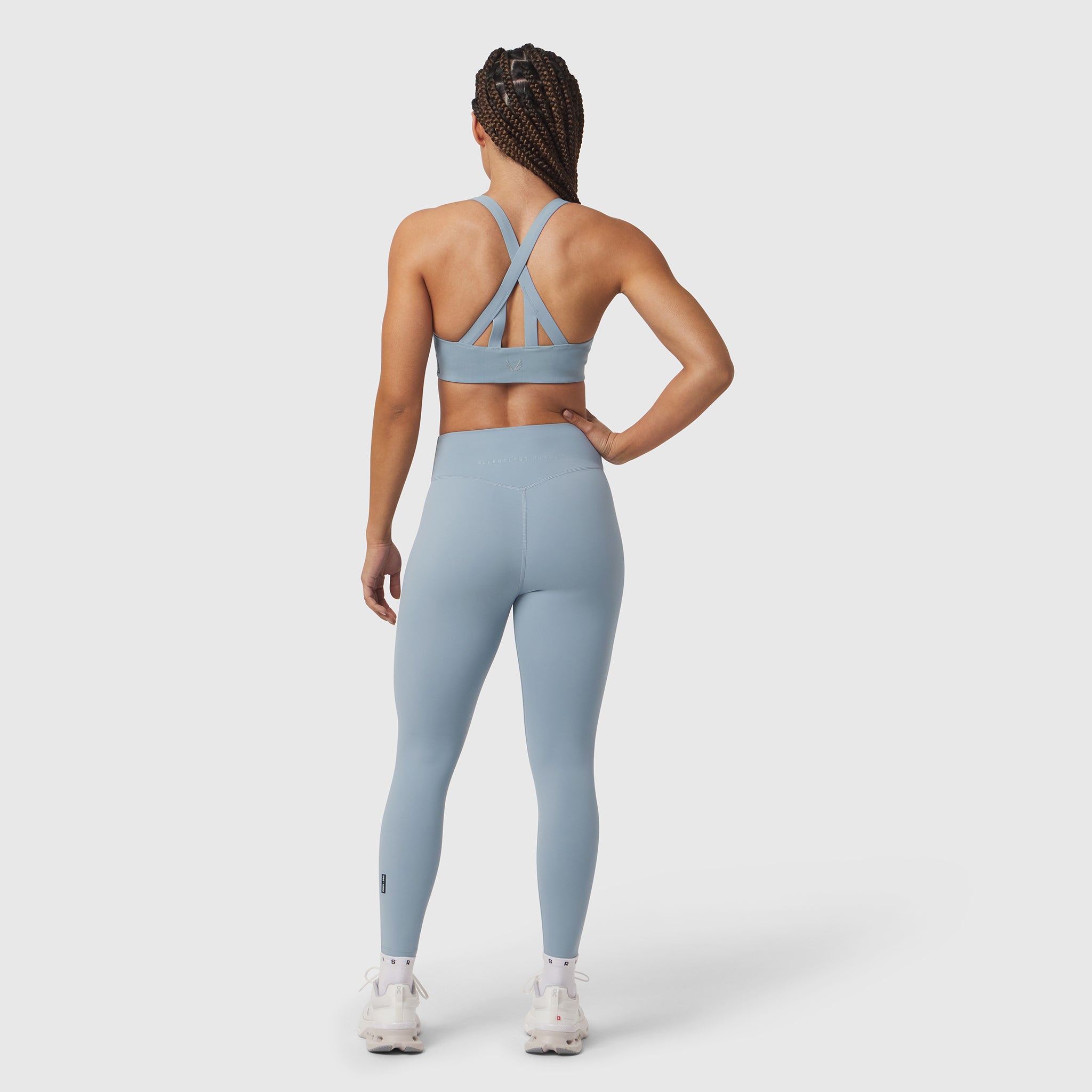 W002 LYCRA® ADAPTIV Legging in light sky, worn by model from behind showing strappy back detail