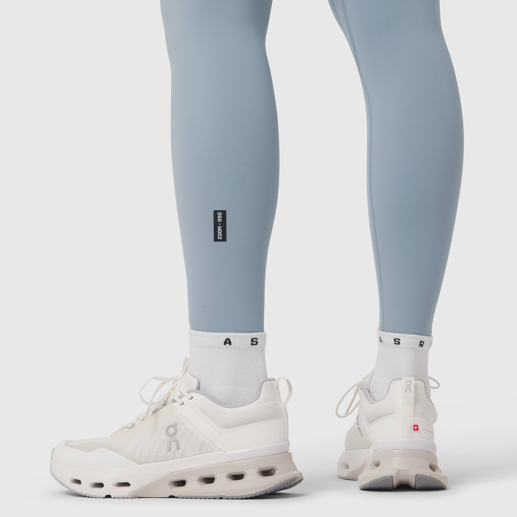 Model wearing light sky LYCRA® ADAPTIV leggings with white socks and white sneakers, front and back view