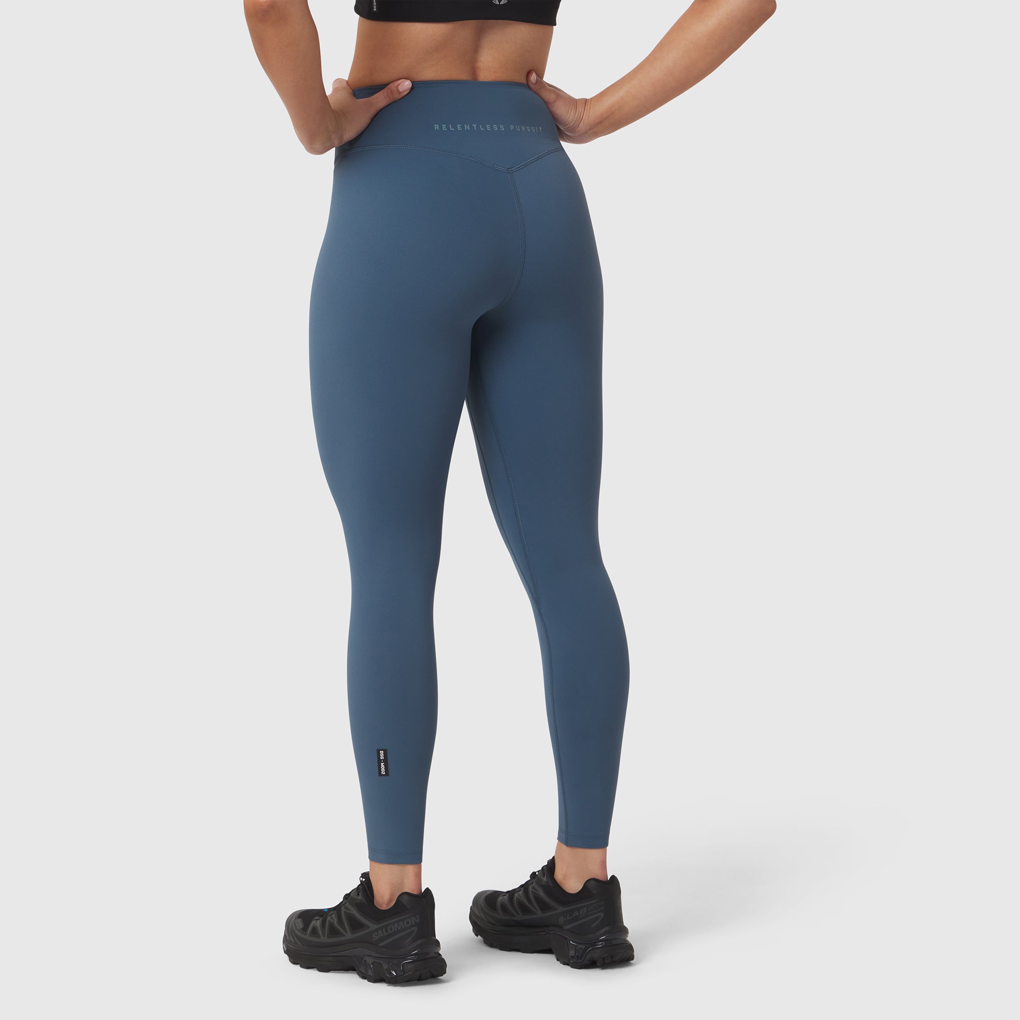 W002 LYCRA ADAPTIV Legging in storm blue, worn by model from behind with hands on hips