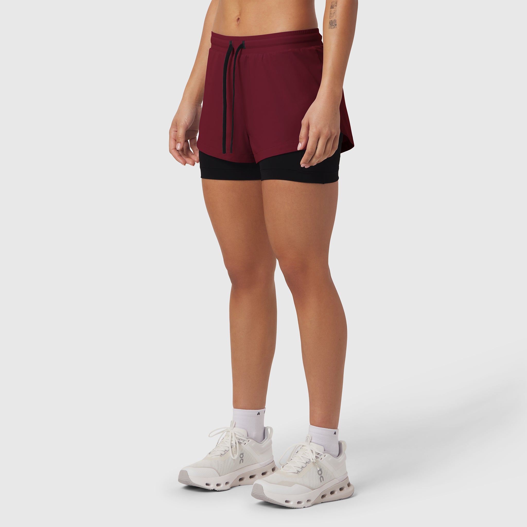 Tetra-Lite® Liner Short in crimson and black, worn by model with white sneakers