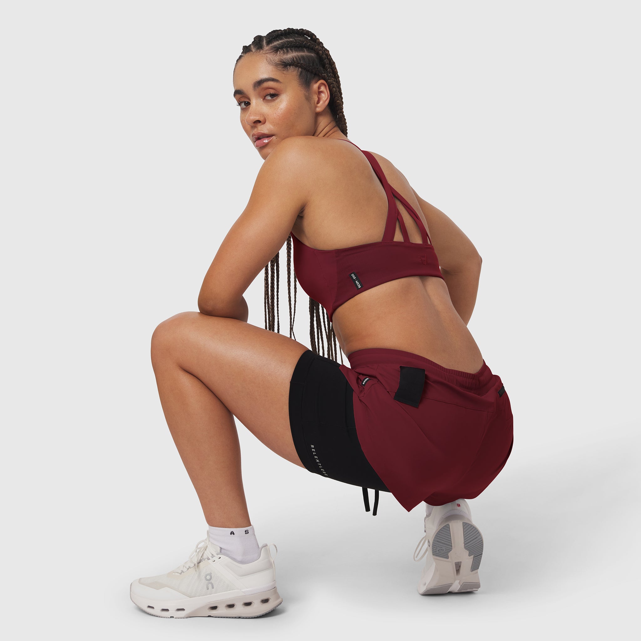 Tetra-Lite® Liner Short in Crimson and Black, worn by model in crouching pose with matching sports bra