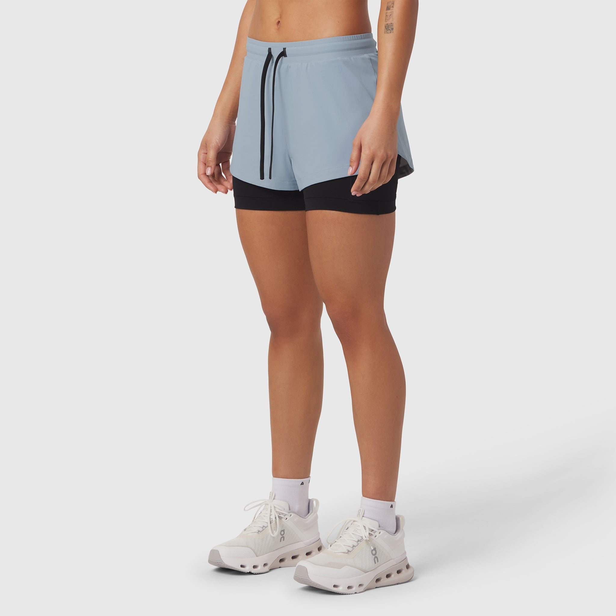 Tetra-Lite Liner Short in light sky and black, worn by model with white sneakers