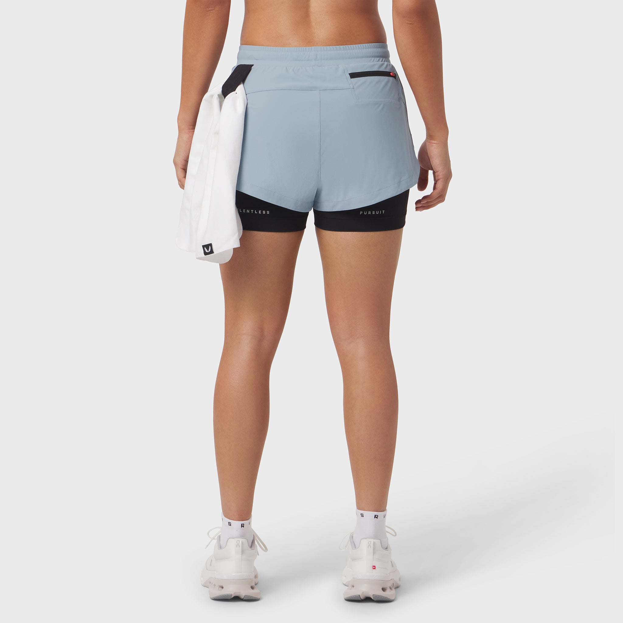 Tetra-Lite Liner Short in light sky and black, back view on model with white towel