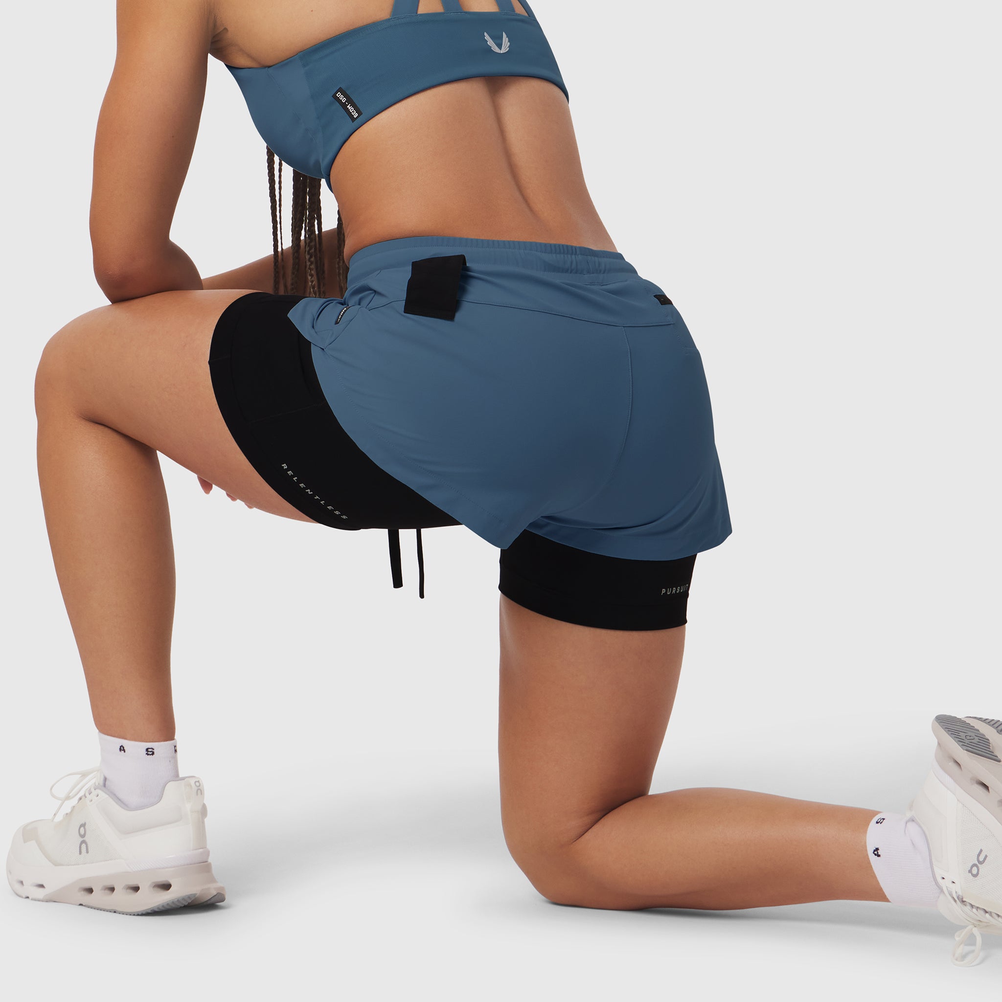 W025 Tetra-Lite Liner Short in storm blue, worn by model in kneeling pose
