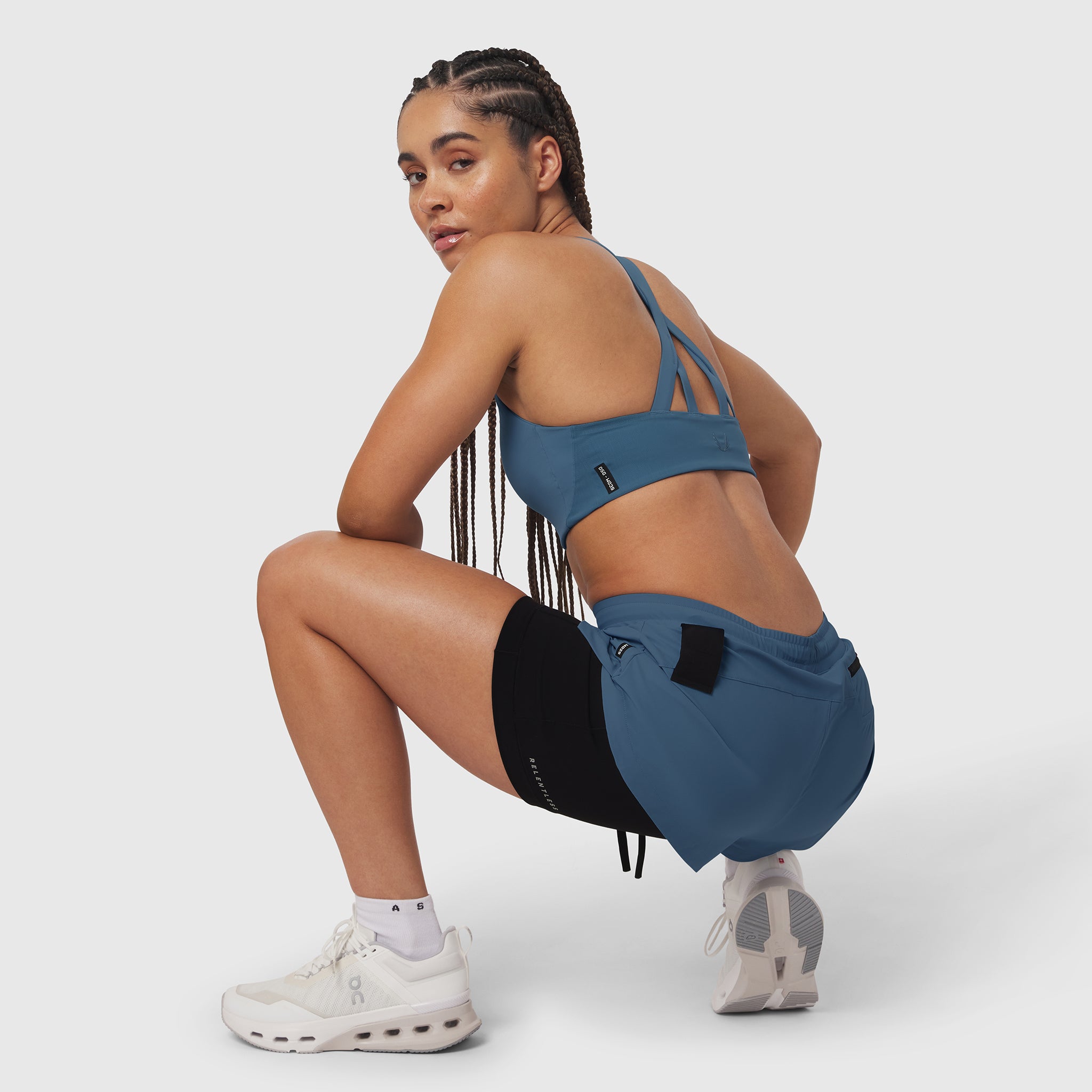 Tetra-Lite Liner Short in storm blue, worn by model in crouching pose with matching sports bra
