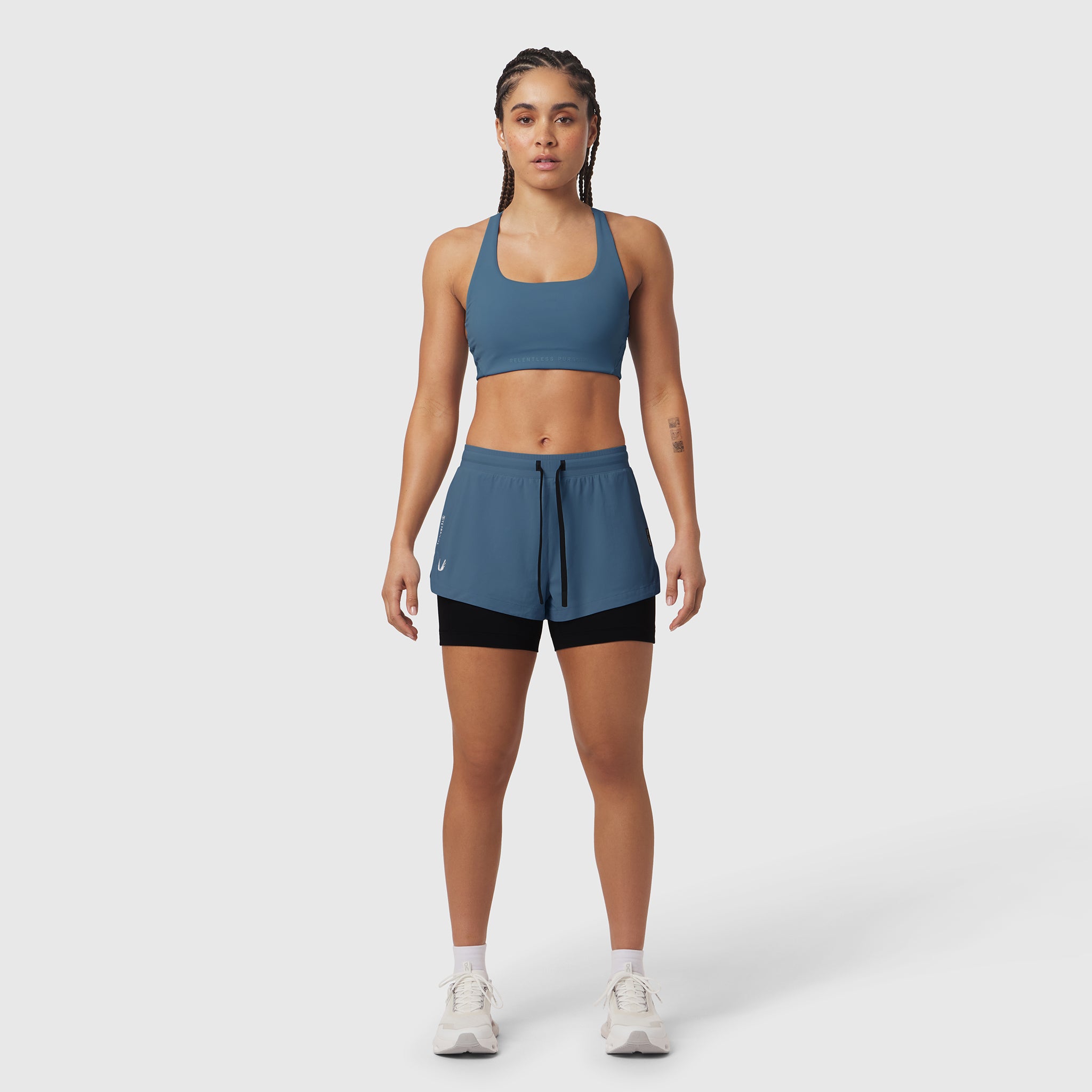 Tetra-Lite Liner Short in storm blue with black liner, worn with matching sports bra, front view