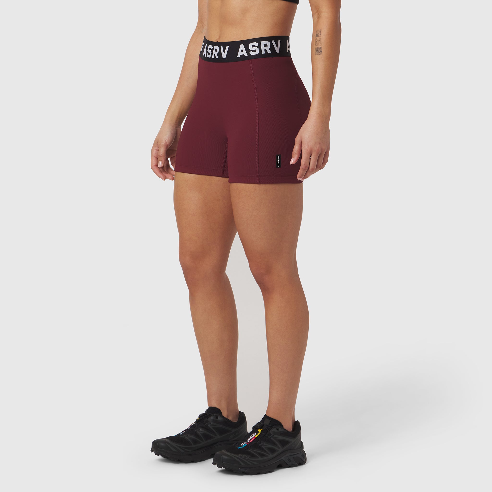 ASRV Lycra Ribbed Short in crimson, worn by model with black sneakers, front view