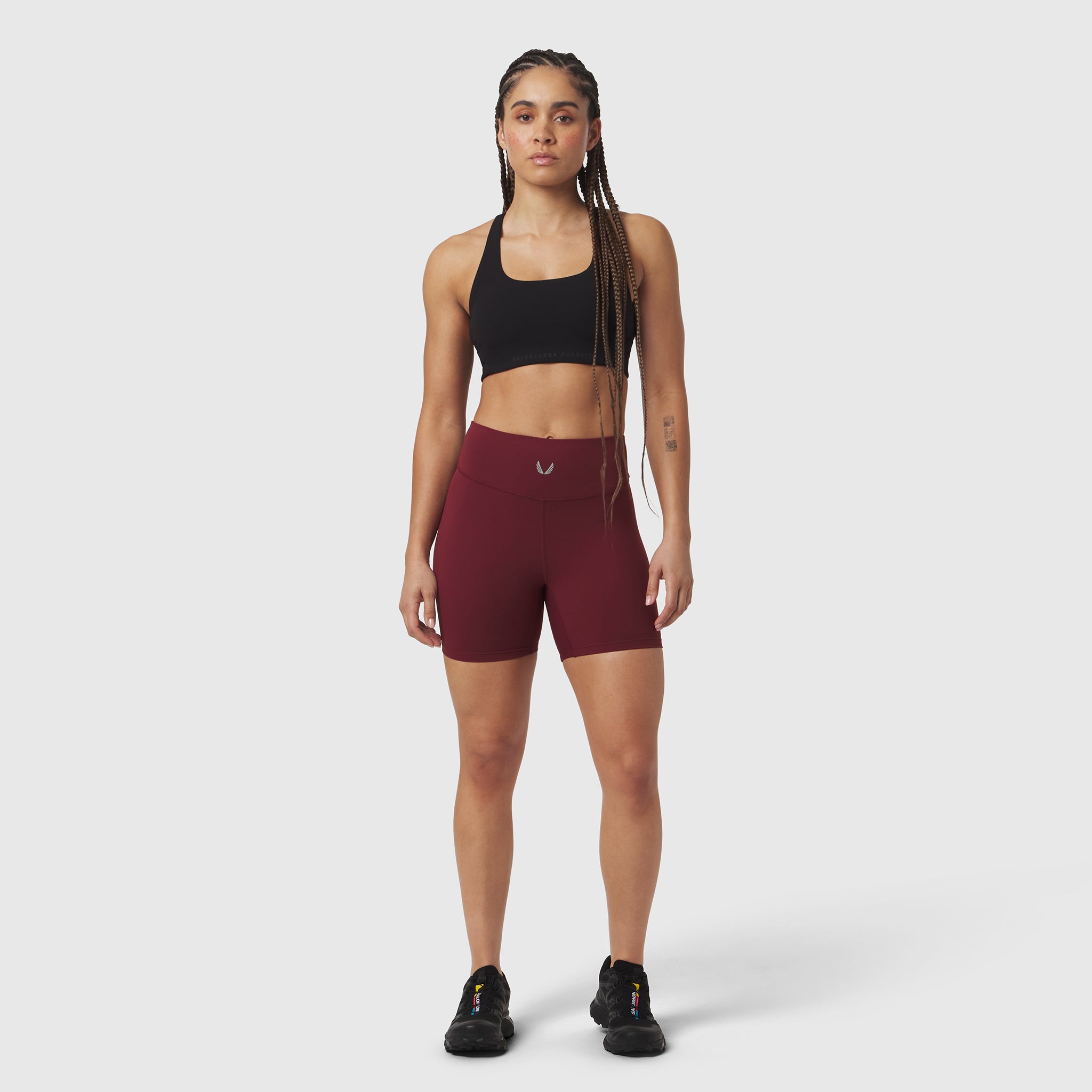 Crimson LYCRA® ADAPTIV biker shorts worn with black sports bra, front-facing pose