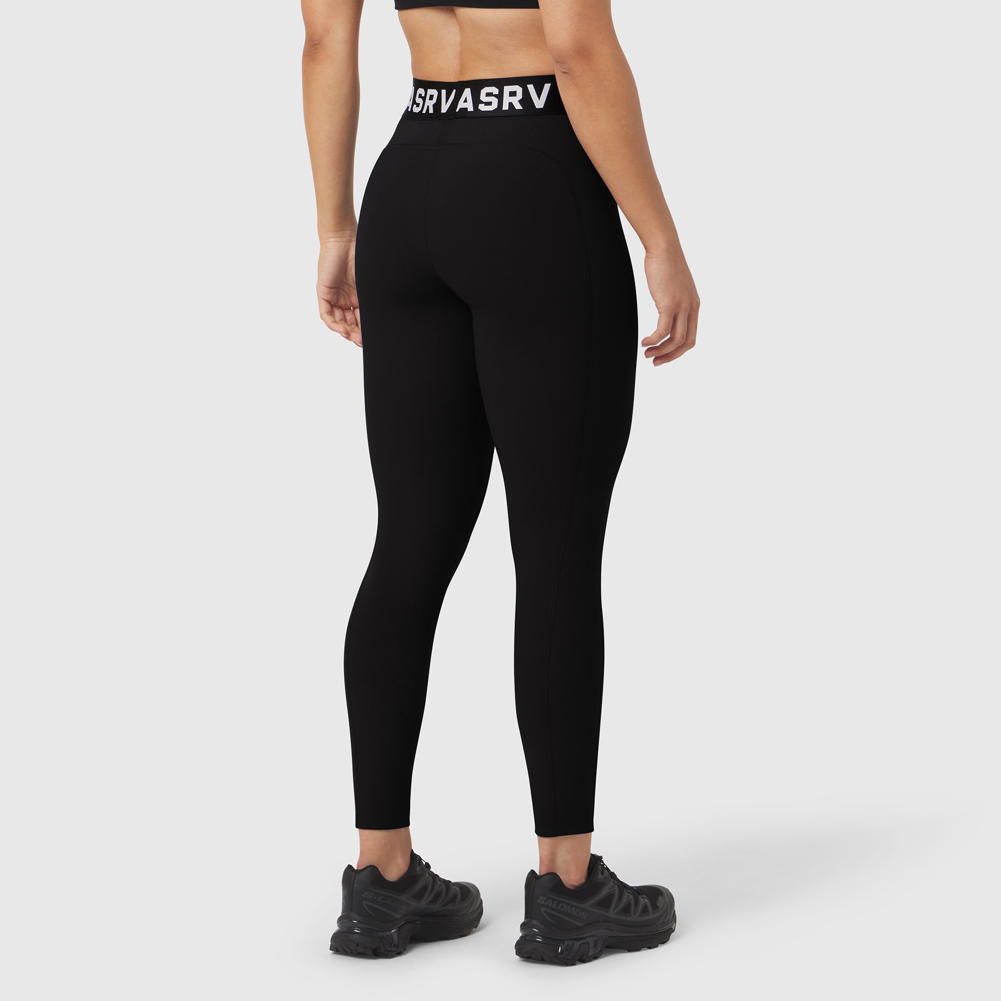 Black LYCRA® ribbed leggings worn by model, back view, with branded waistband