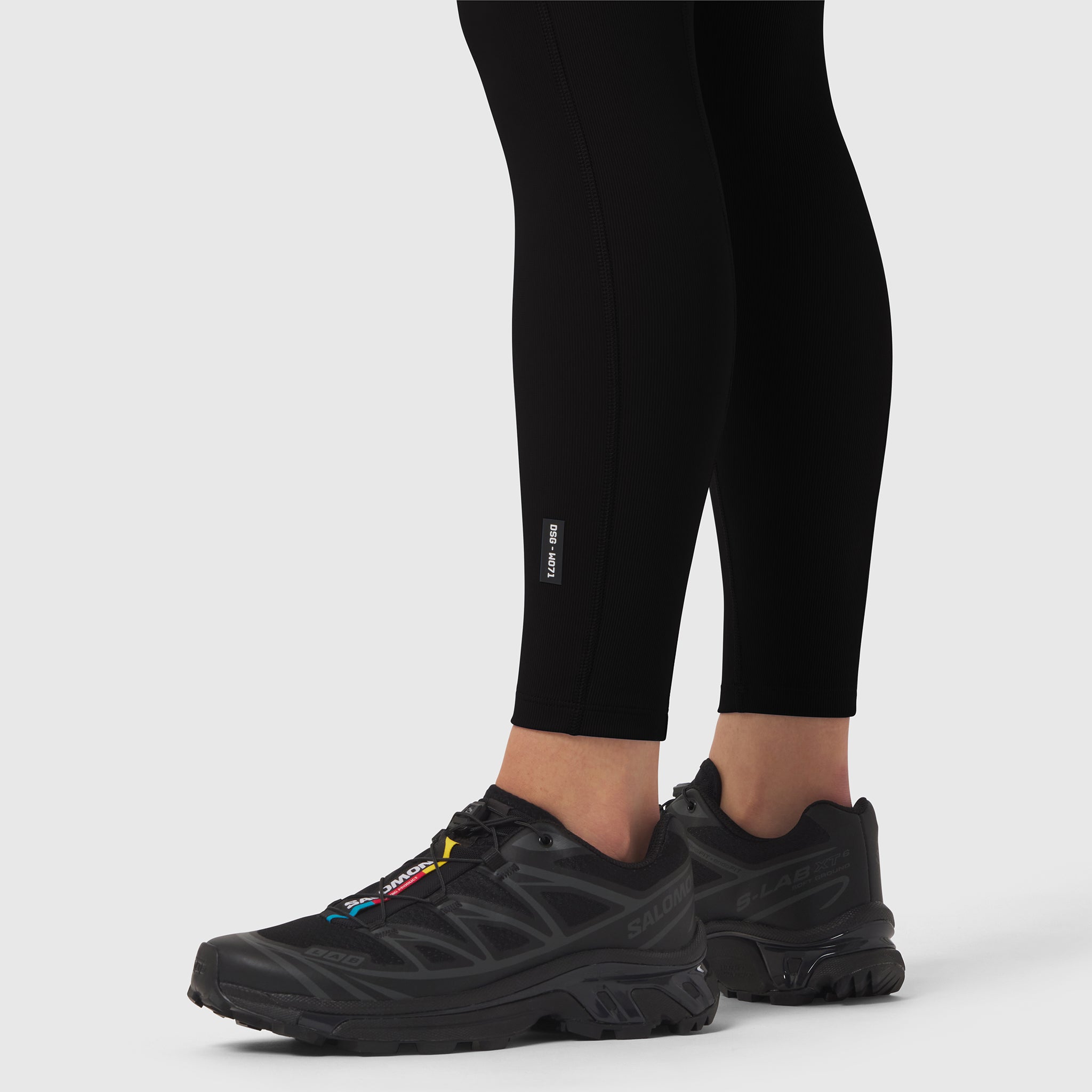 Black LYCRA® Ribbed Legging worn with black sneakers, cropped leg view