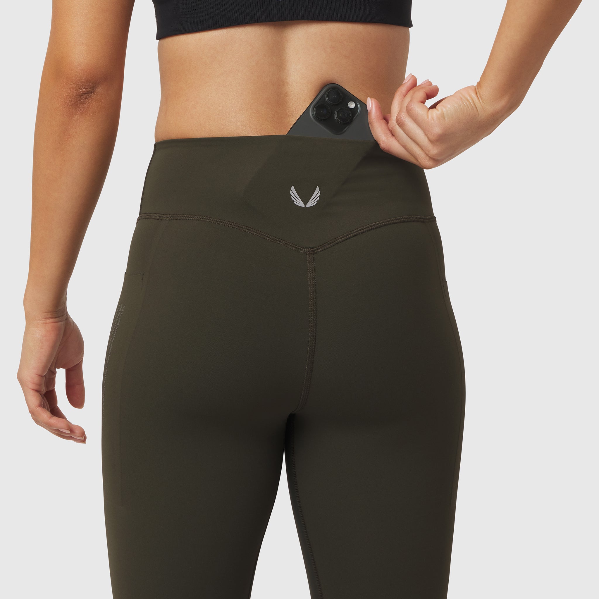 W072 LYCRA® ADAPTIV 4 Pocket Legging in olive, worn by model demonstrating phone pocket functionality