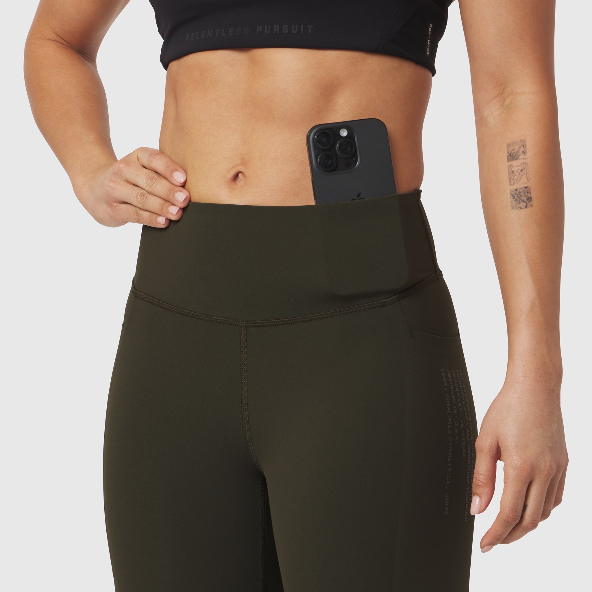 W072 Lycra Adaptiv 4 Pocket Legging in olive, worn by model holding phone in waistband pocket
